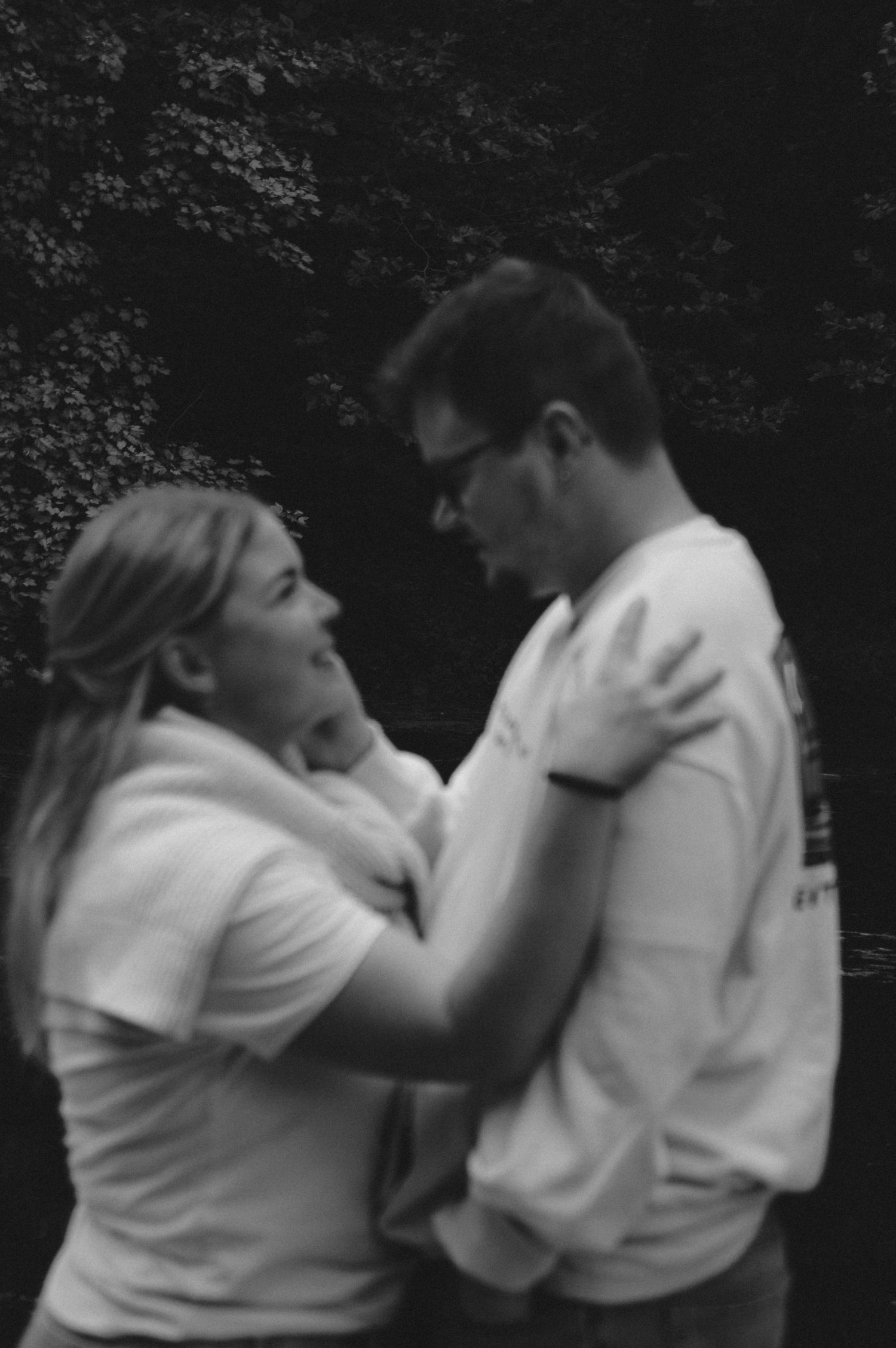Black and white candid sequence of couple sharing emotional moment outdoors.