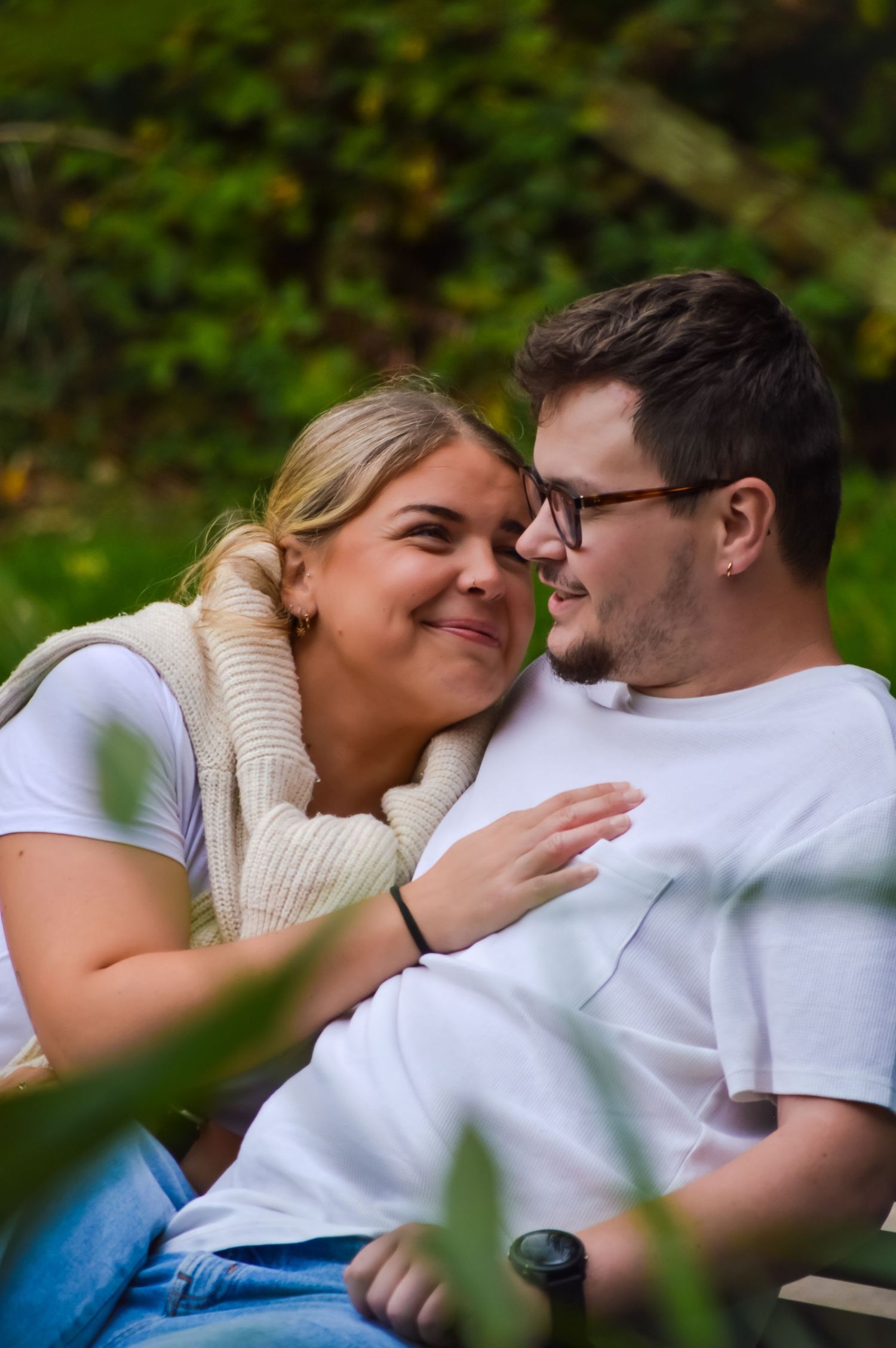 Couple sharing loving moment outdoors while relaxing in casual attire.