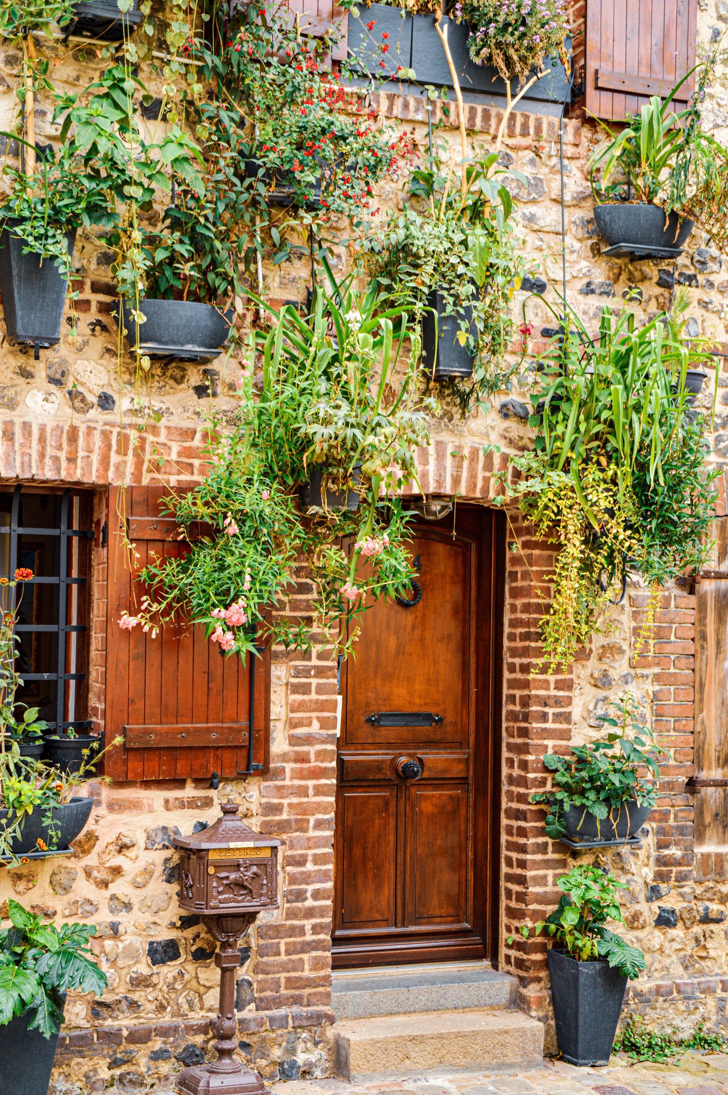 Charming brick facade with wooden doors and climbing plants adorning the entrance.