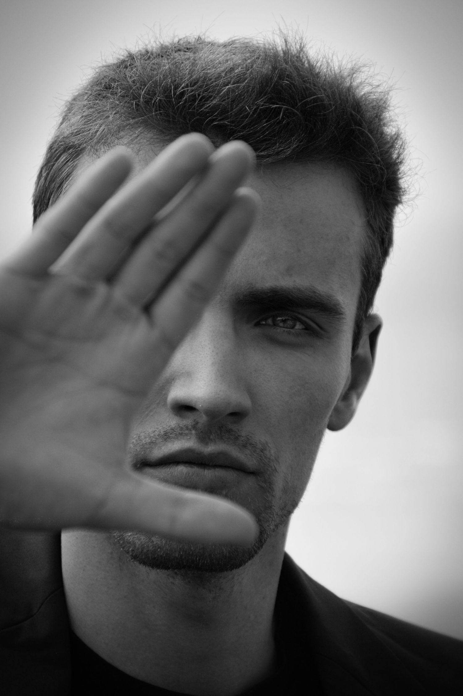 Artistic black and white portrait sequence showing a hand covering different parts of the face.