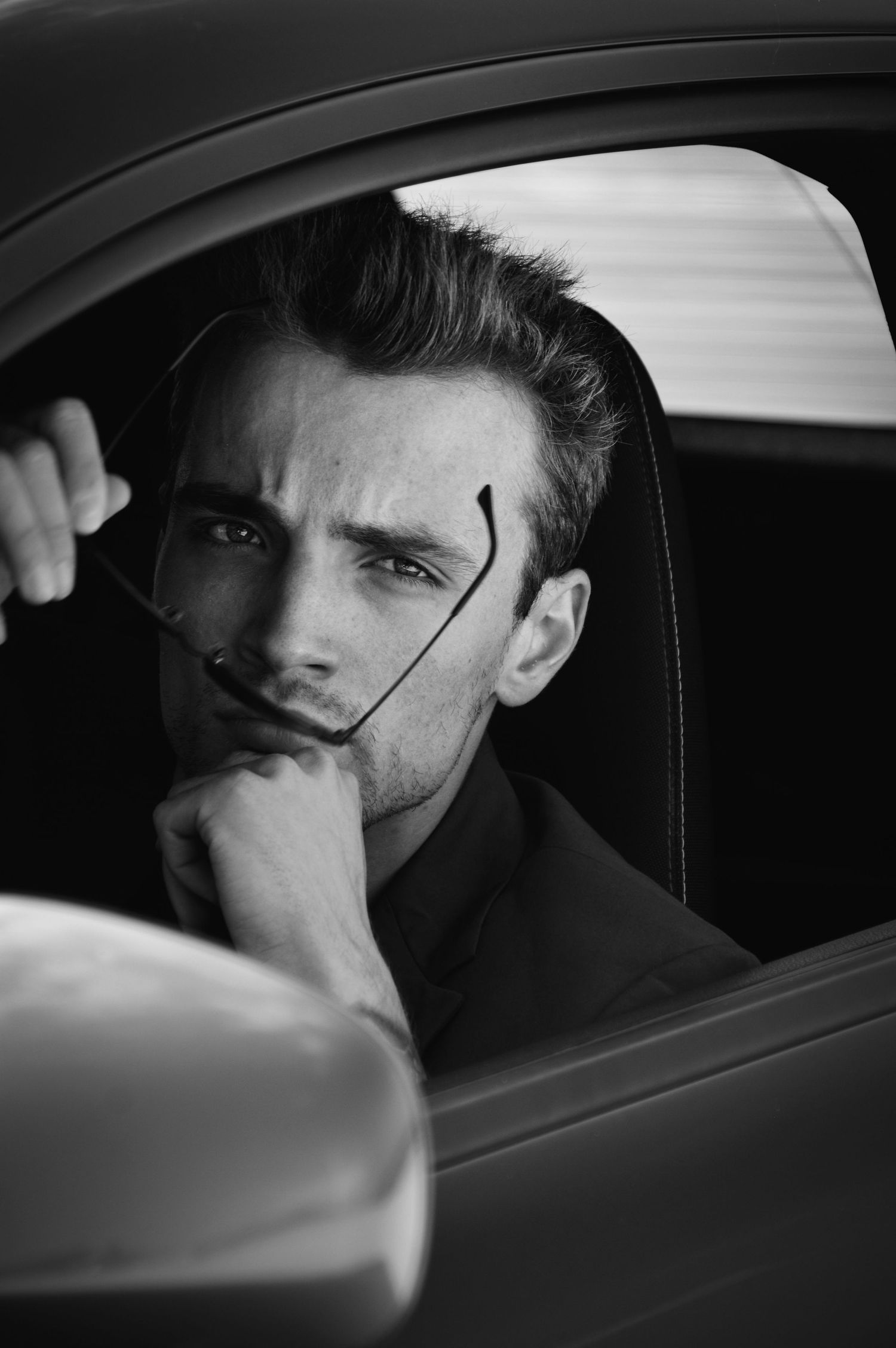 Dramatic black and white portrait series of person sitting in car.