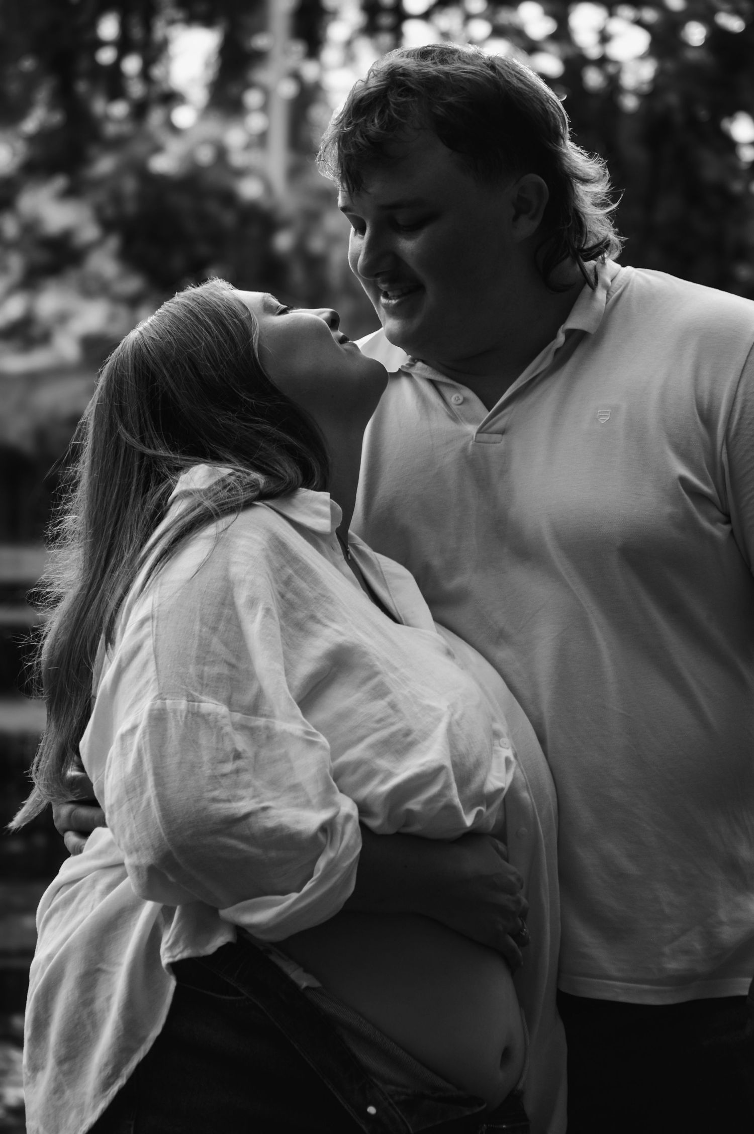 A romantic black and white photo series of a couple embracing in an intimate dance pose outdoors.