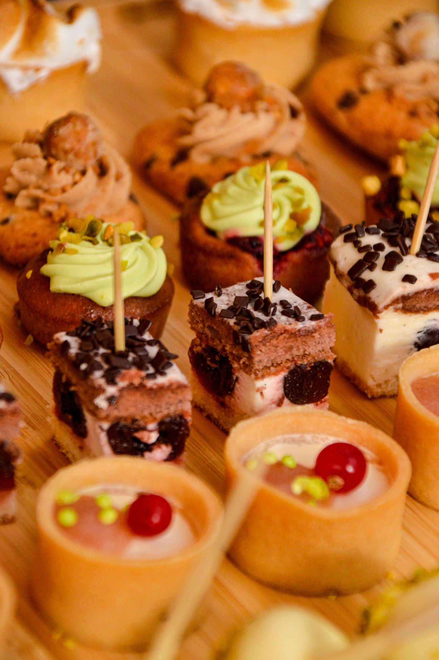 Elegant dessert display featuring mini pastries topped with chocolate and cream.