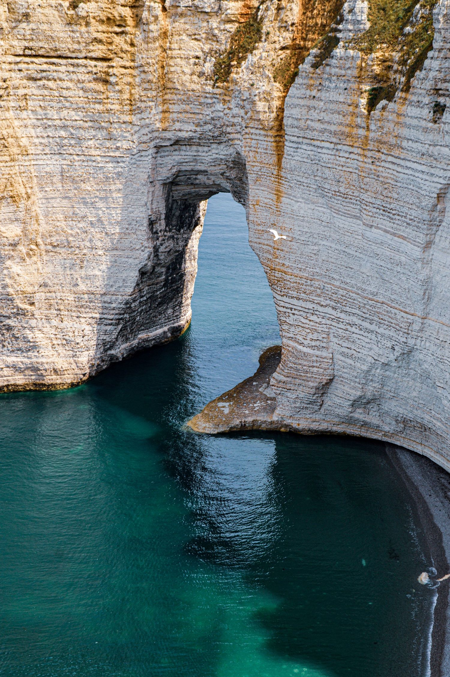 Dramatic white limestone cliffs meet turquoise waters along a scenic coastal formation.