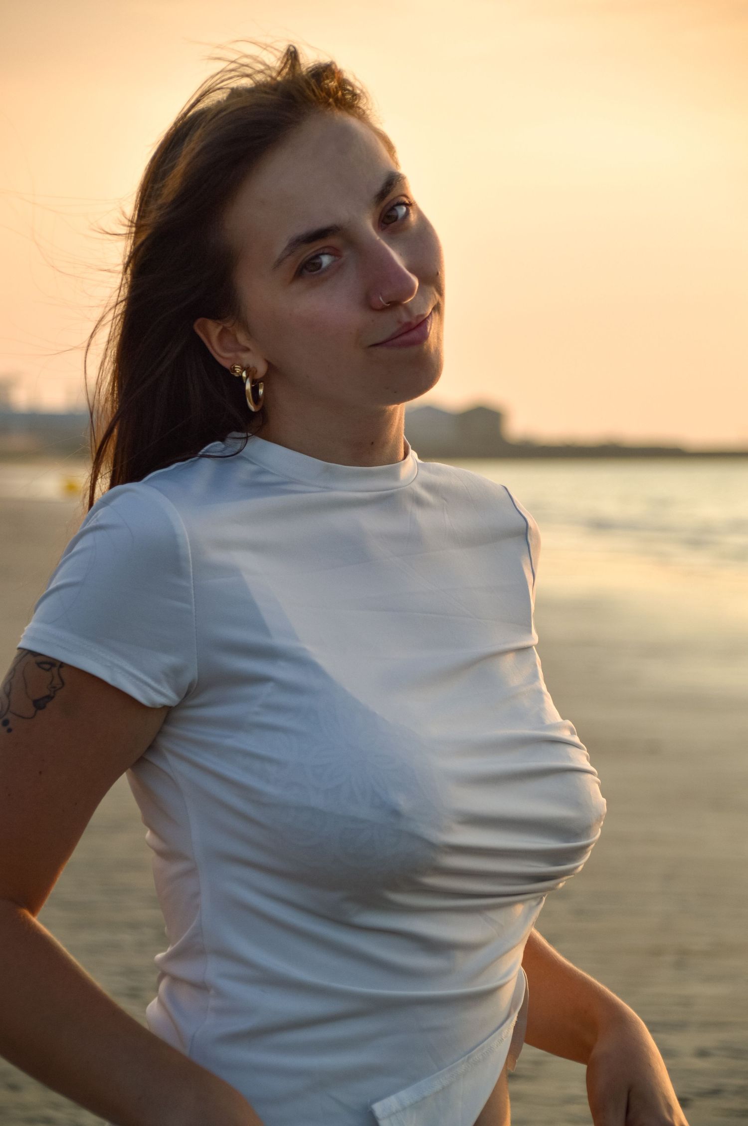 Artistic beach photoshoot with dramatic sunset lighting.
