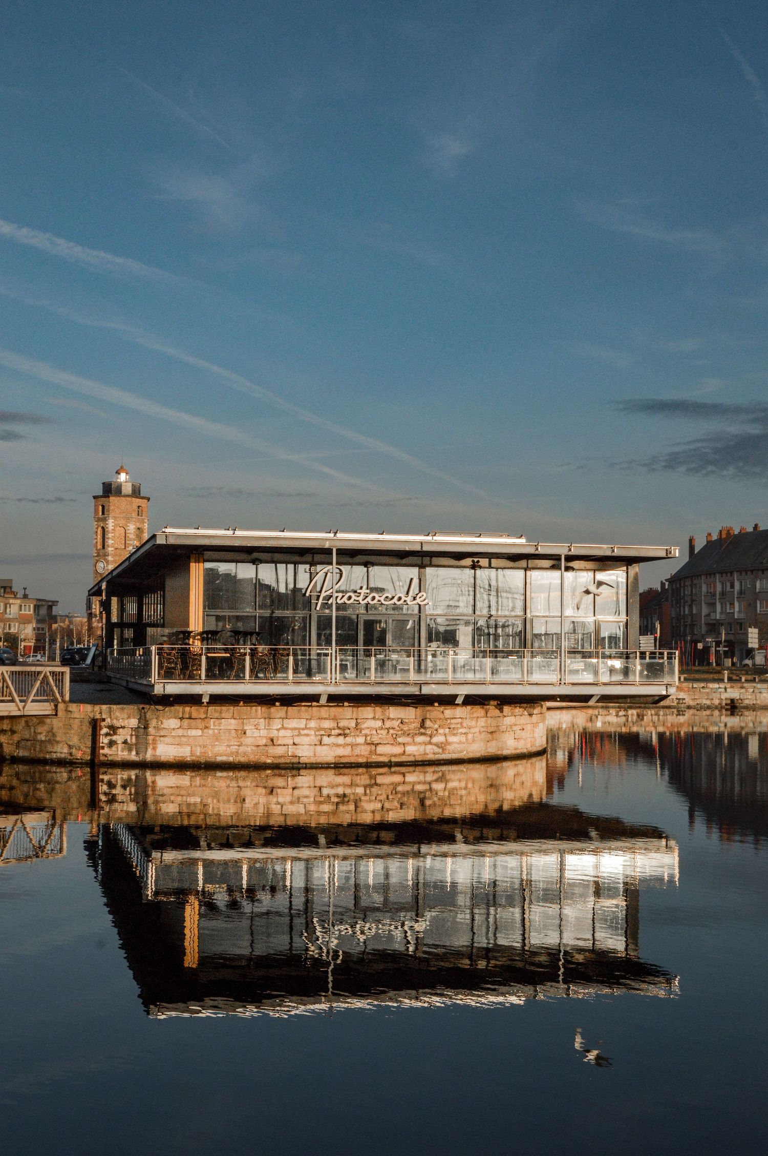 Modern waterfront pier and dock structures reflecting in calm harbor waters.