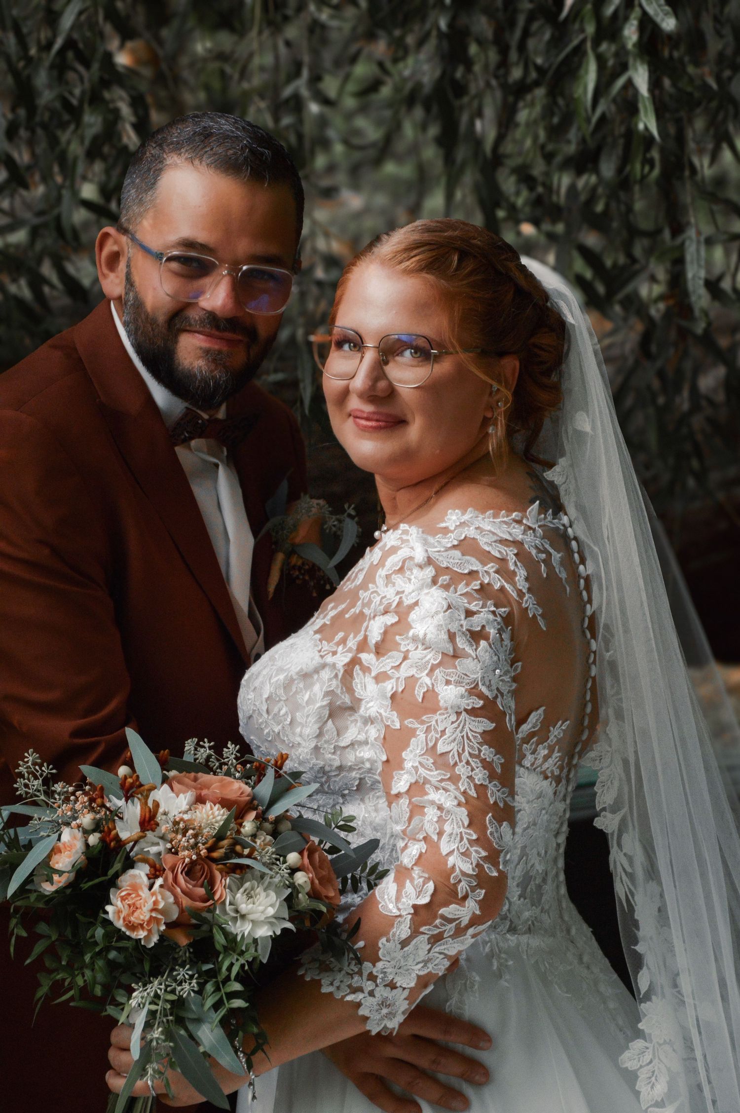 Wedding portraits featuring a couple against a natural backdrop with greenery and soft lighting.
