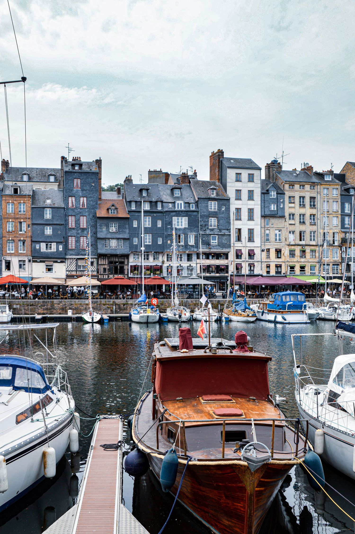 Colorful historic buildings and boats at a French harbor waterfront.