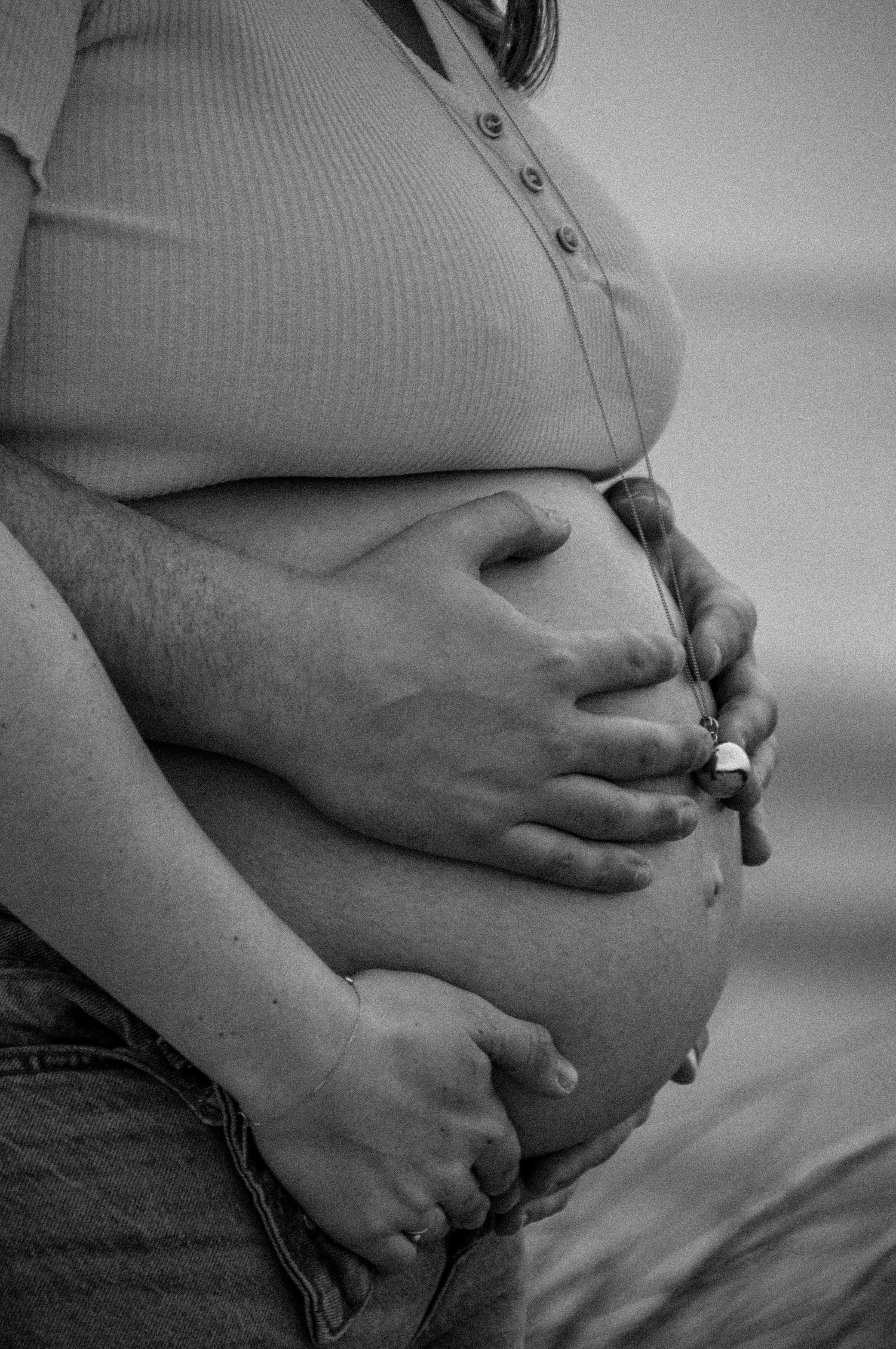 Close-up view of a pregnant belly in black and white.
