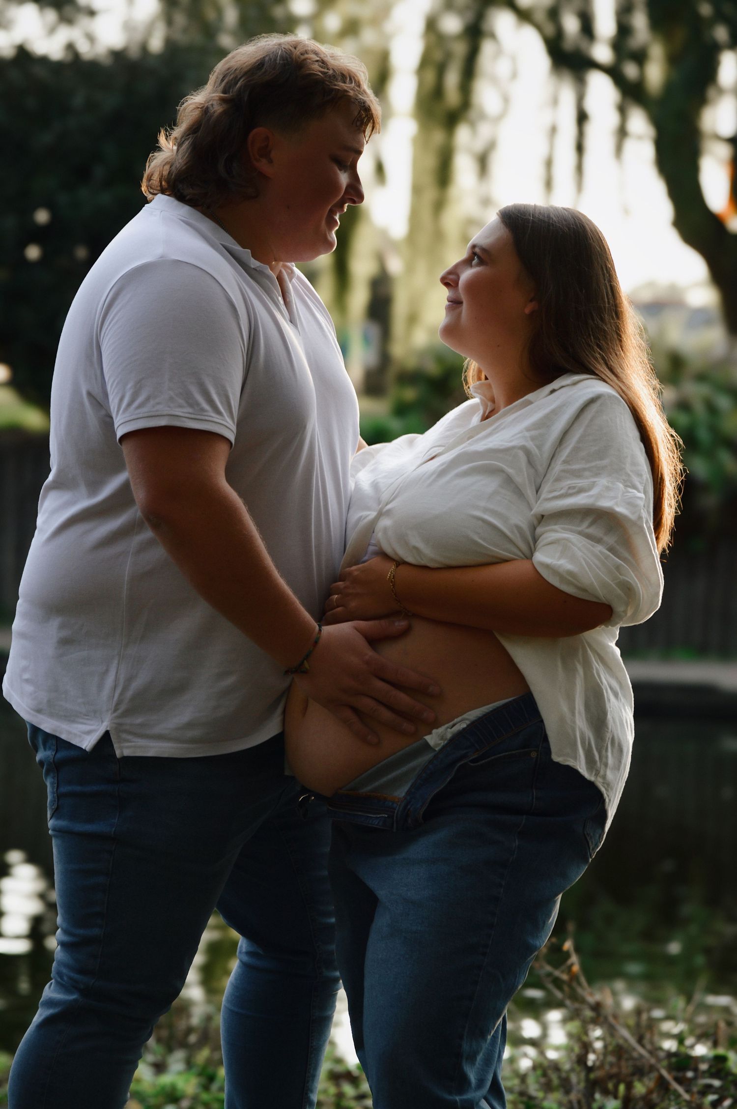 Playful couple's photoshoot in a park setting showing joyful interactions and natural poses.