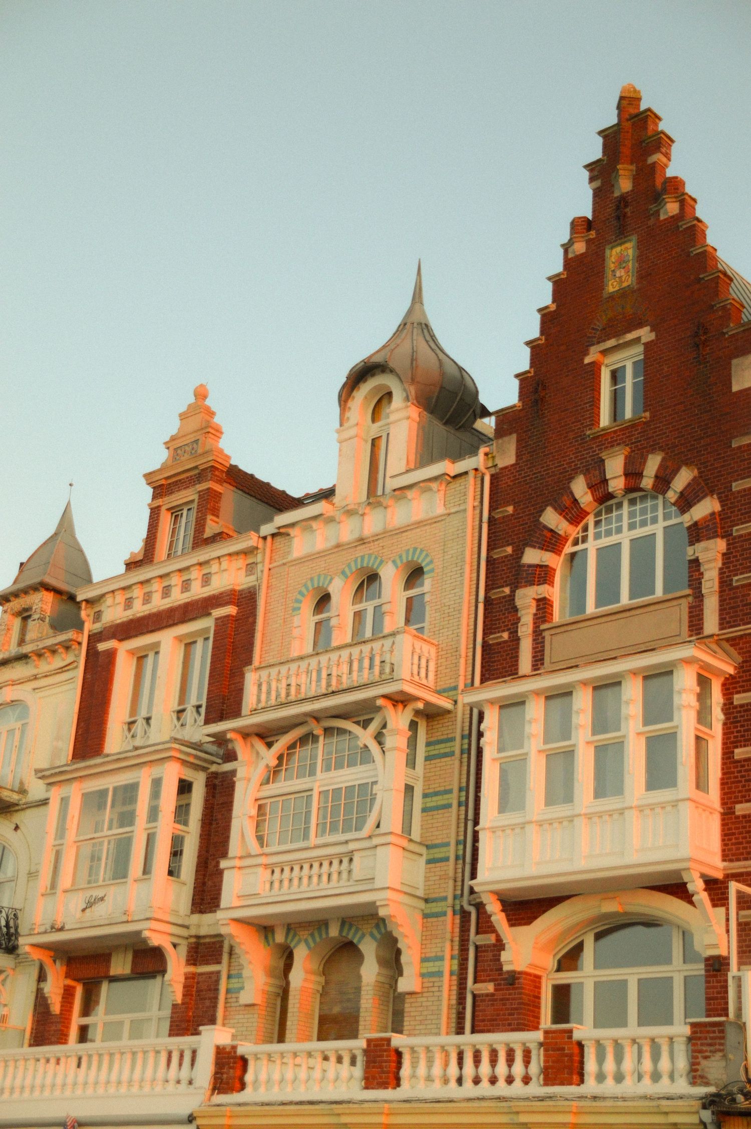 Historic Dutch-style row houses with ornate red brick facades and white trim.