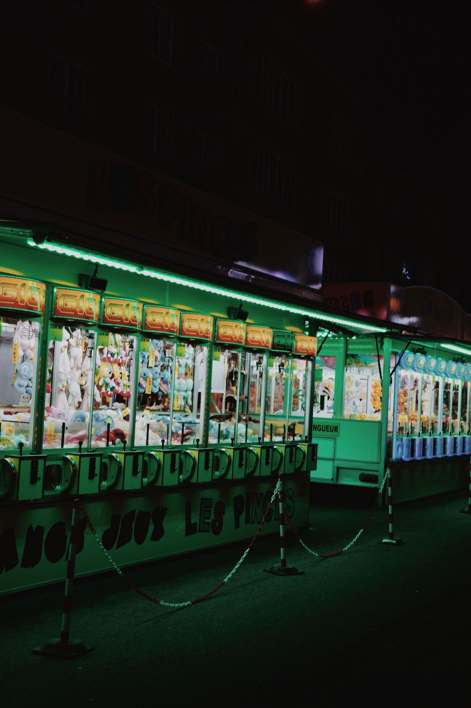 Dark carnival shooting gallery with green neon lighting and target games.