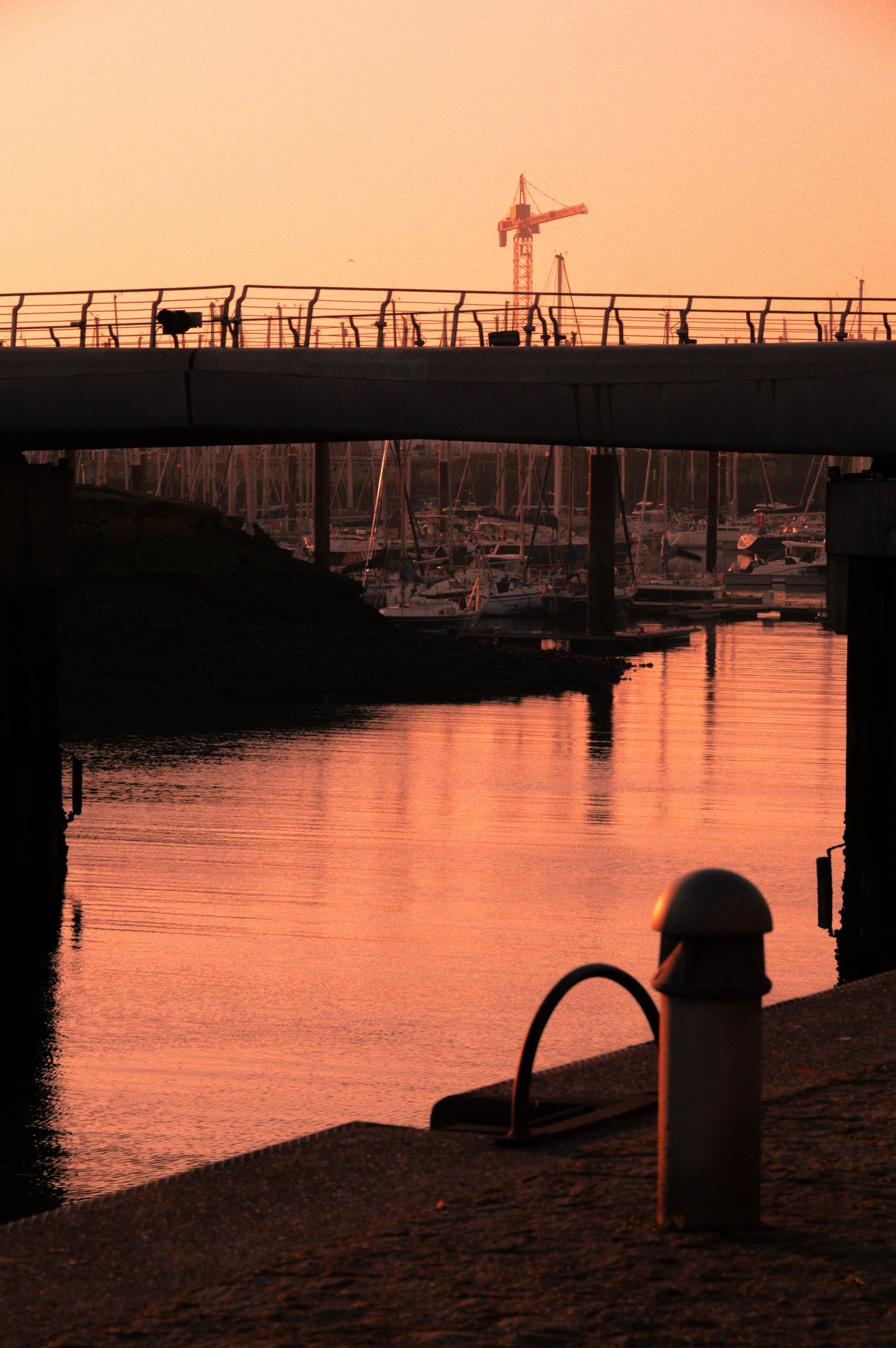 A panoramic sequence of sunset silhouettes at a marina dock with boats and orange sky reflecting on calm waters.