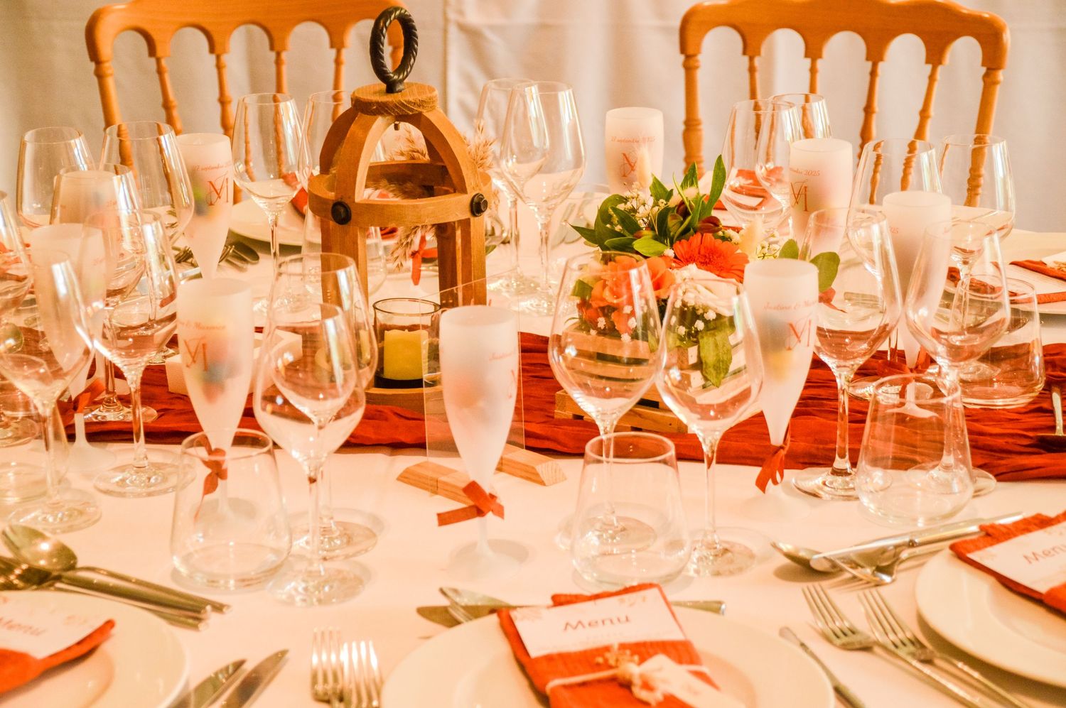 Elegant table setting with wine glasses and lantern centerpiece for formal dining.