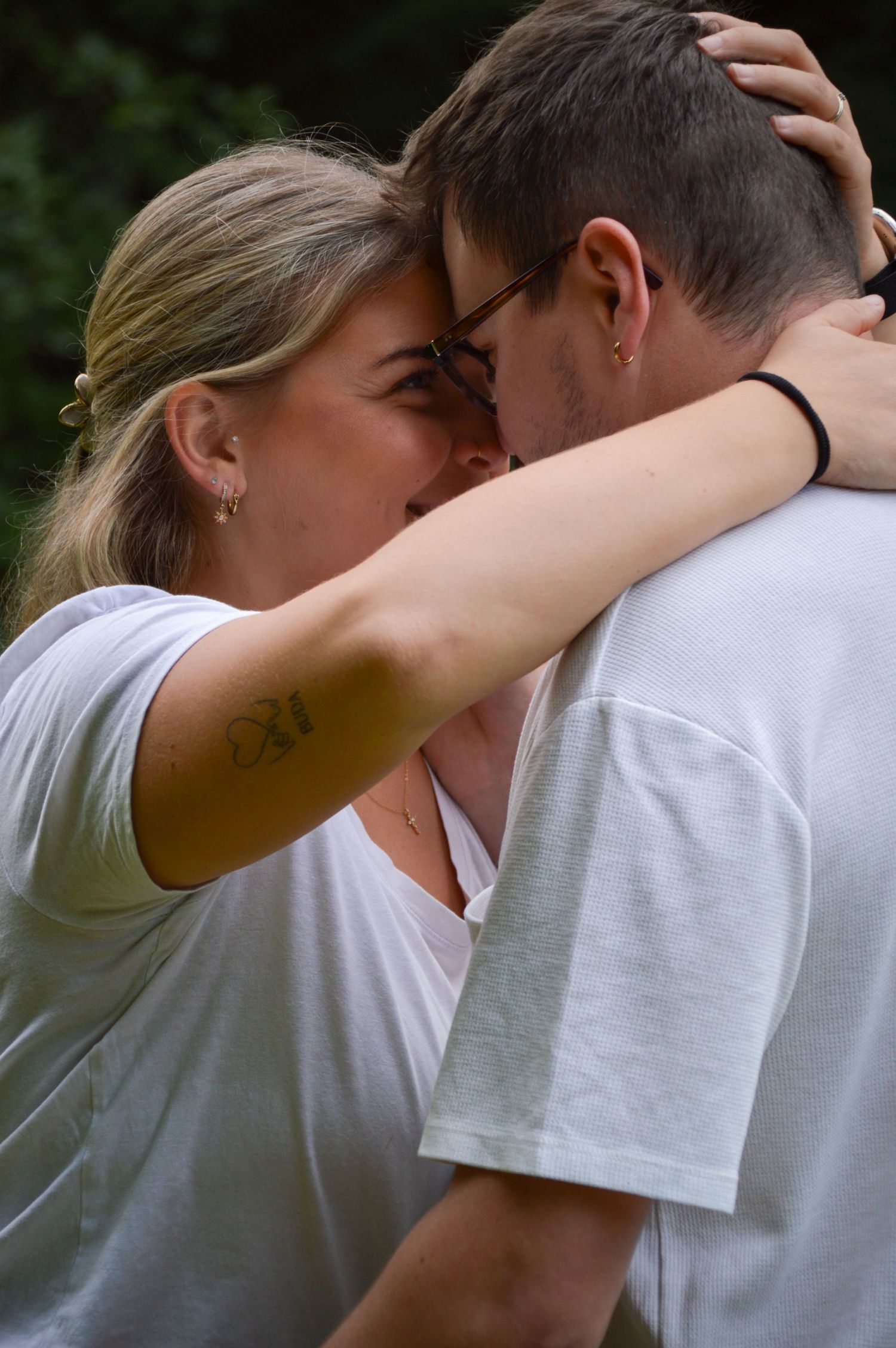 Close-up sequence of an intimate embrace between two people wearing white shirts.