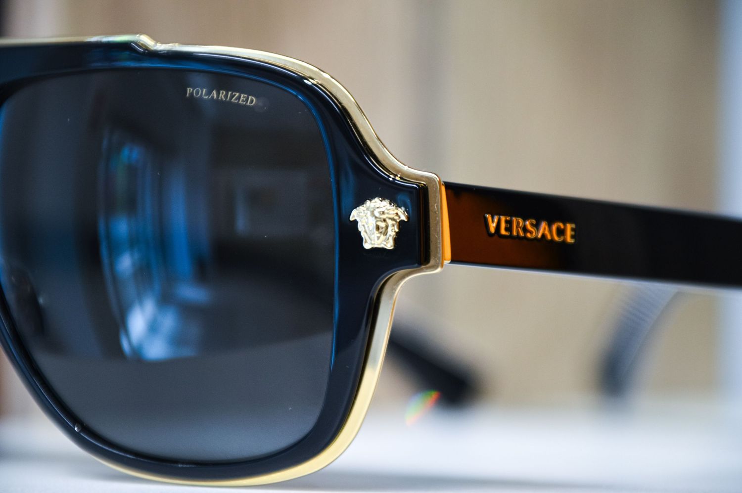 Luxury Versace sunglasses with gold detailing displayed on white surface.