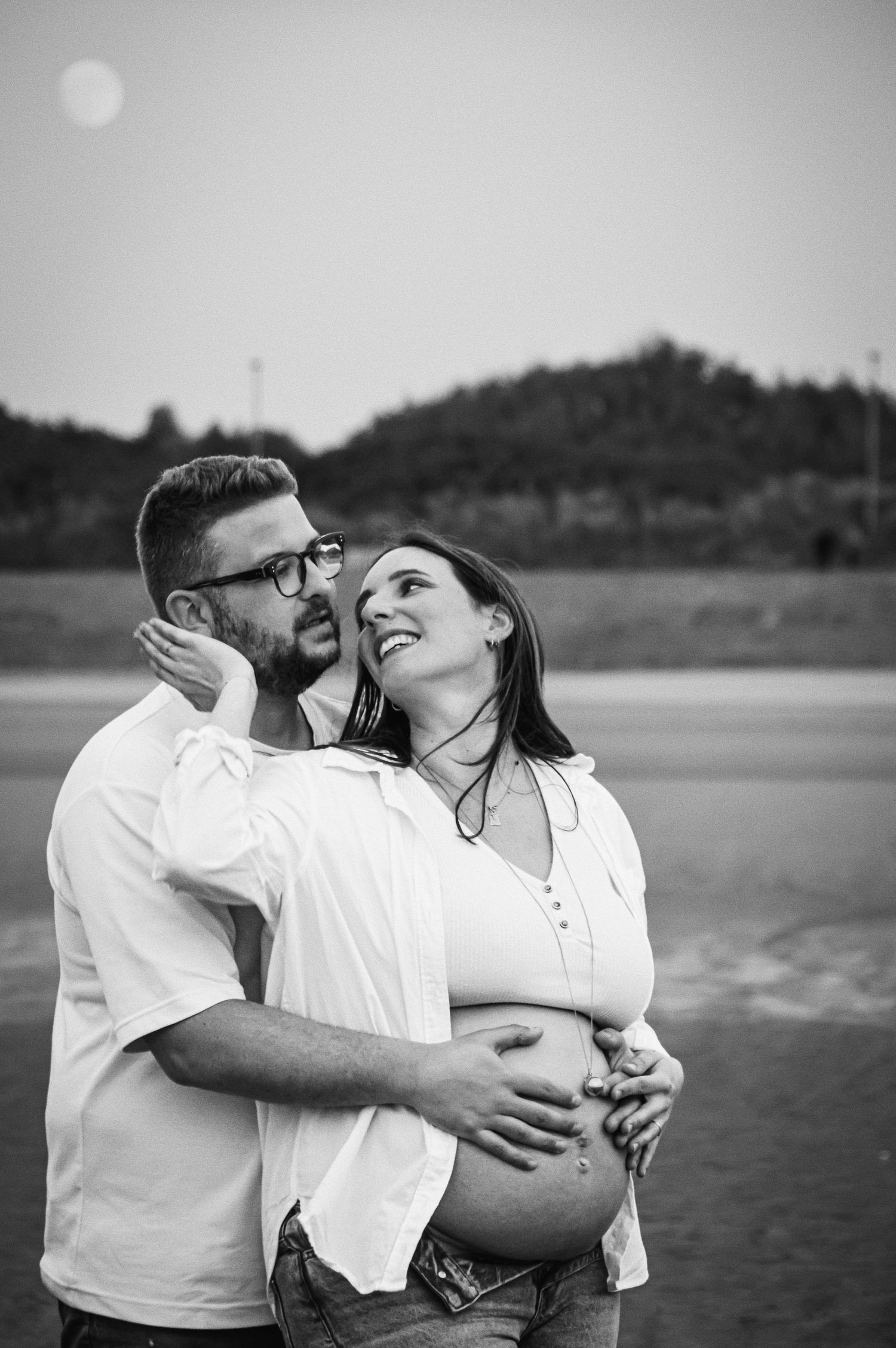 Intimate maternity beach photos with loving embraces.