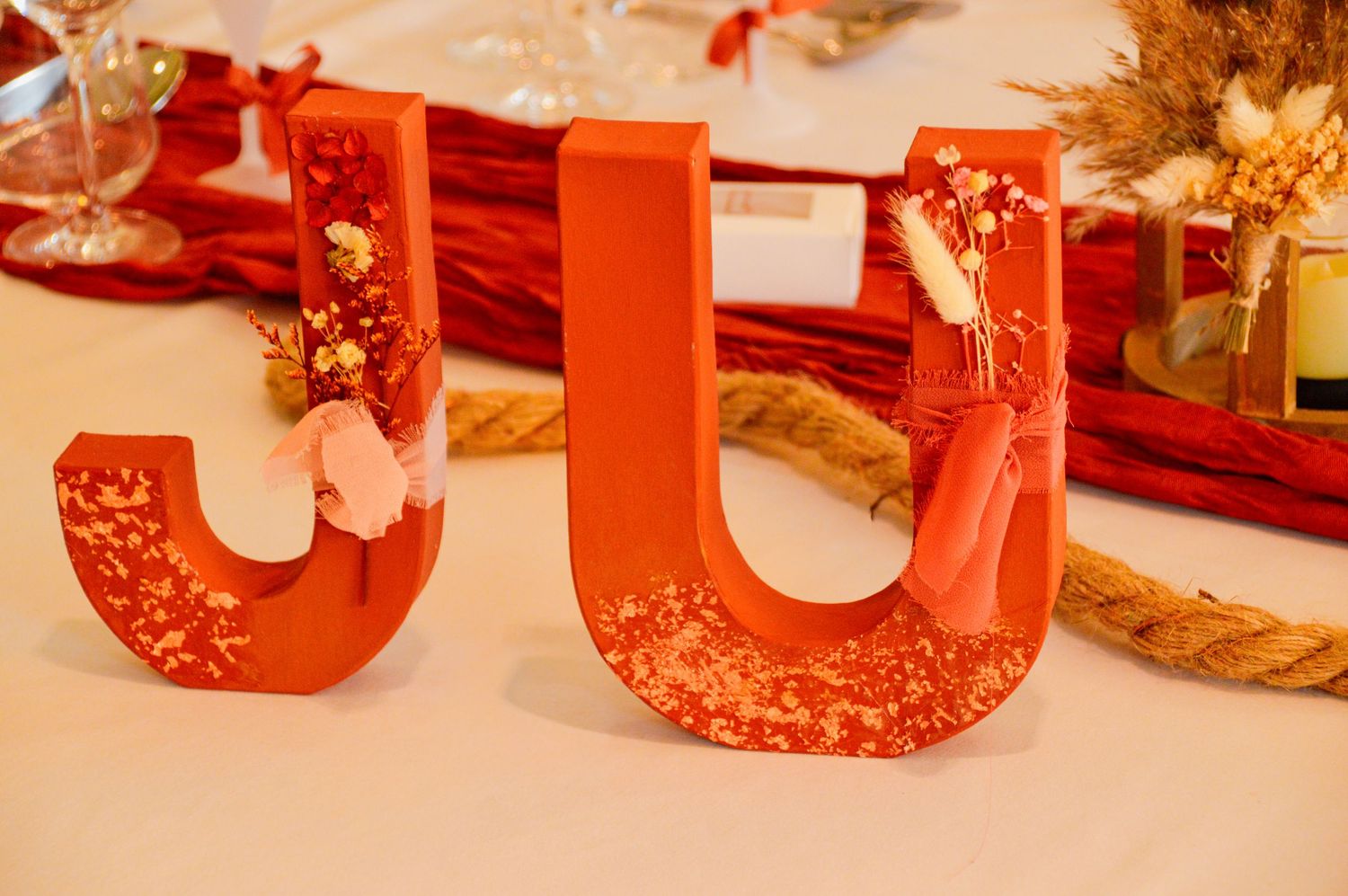 Decorative red letters 'JJ' with intricate patterns displayed on white surface.