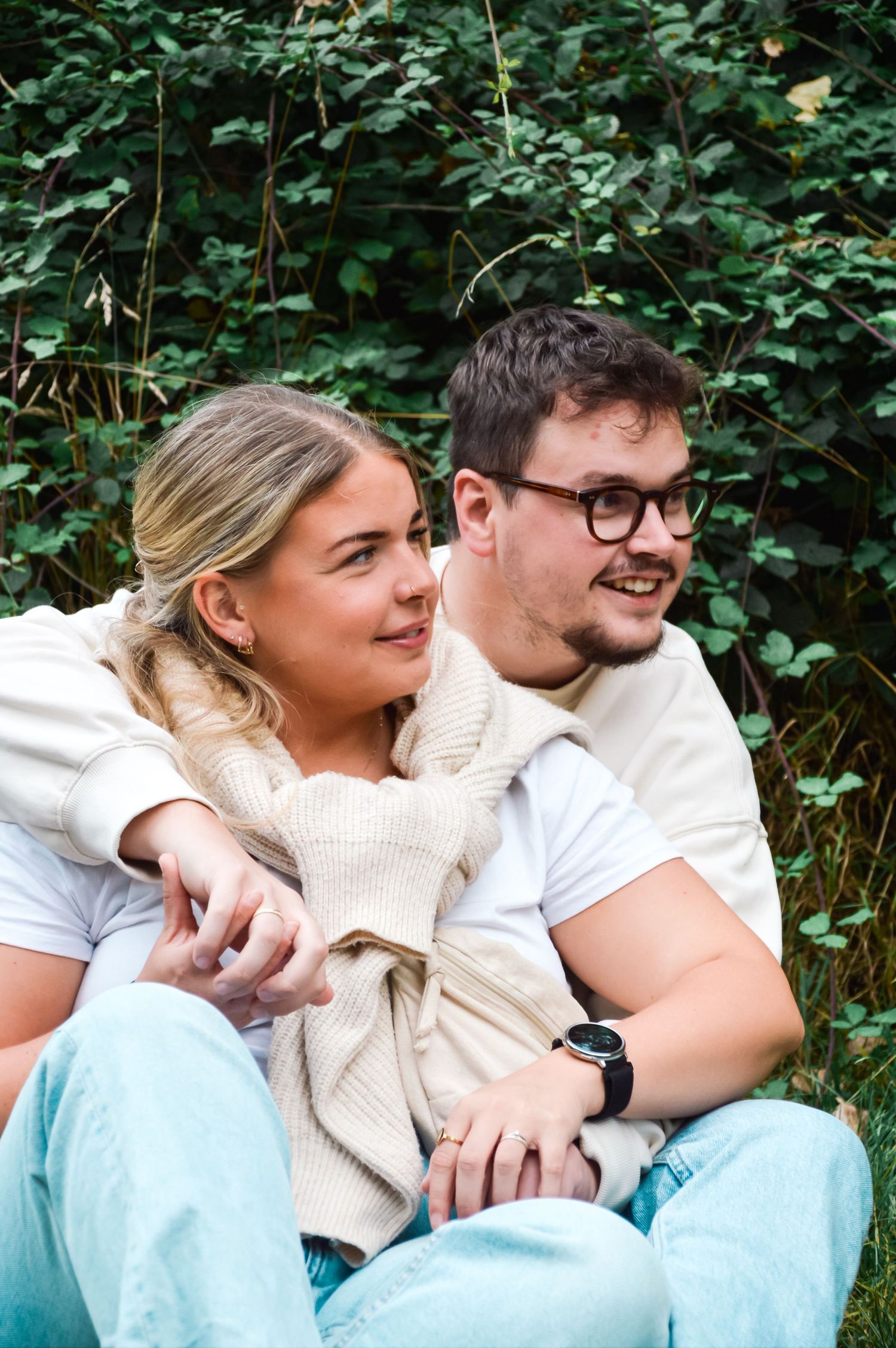 Couple sharing an intimate moment while sitting together outdoors in casual attire.