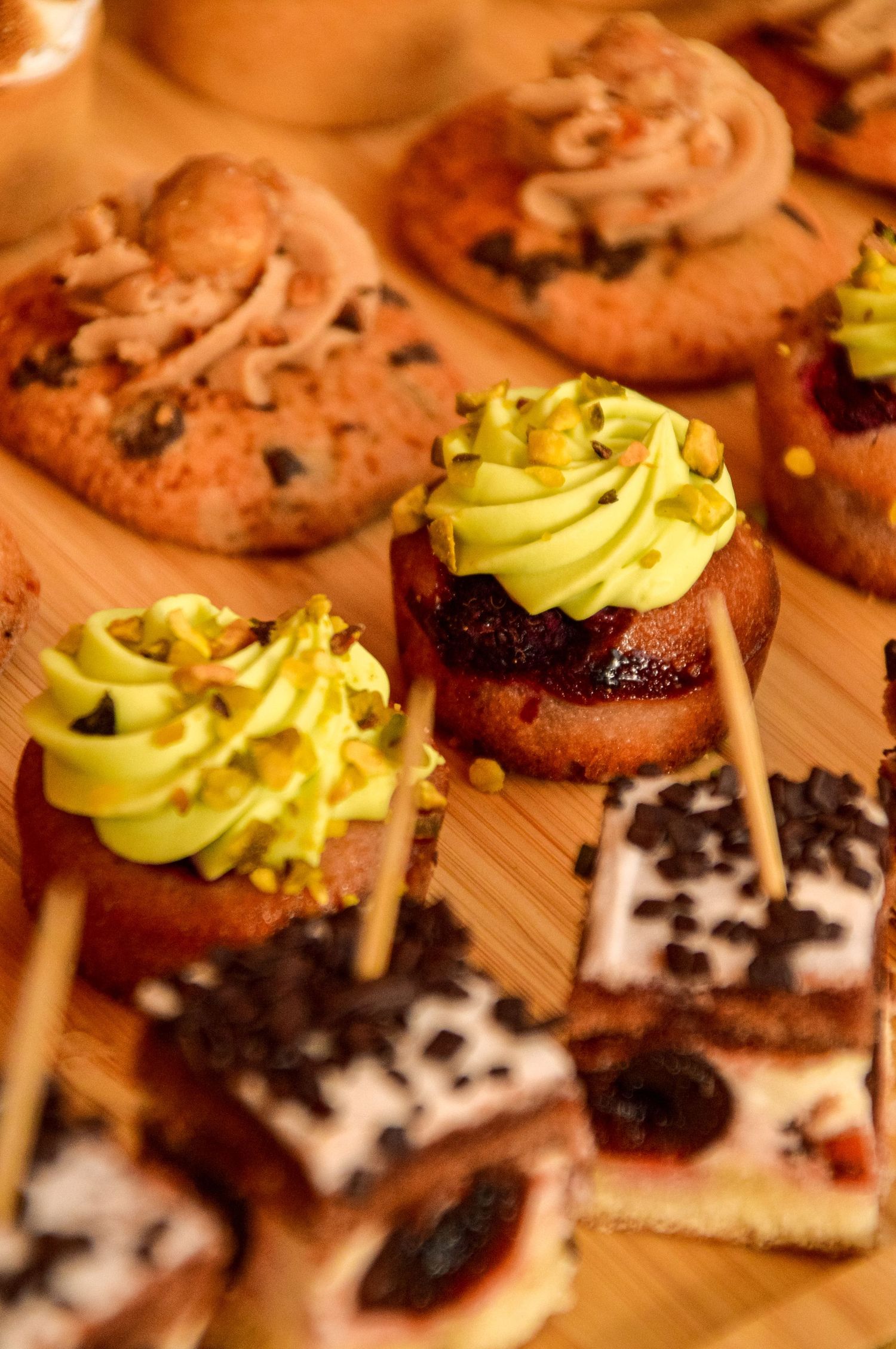 Close-up of gourmet appetizers with avocado cream and chocolate garnish on wooden board.