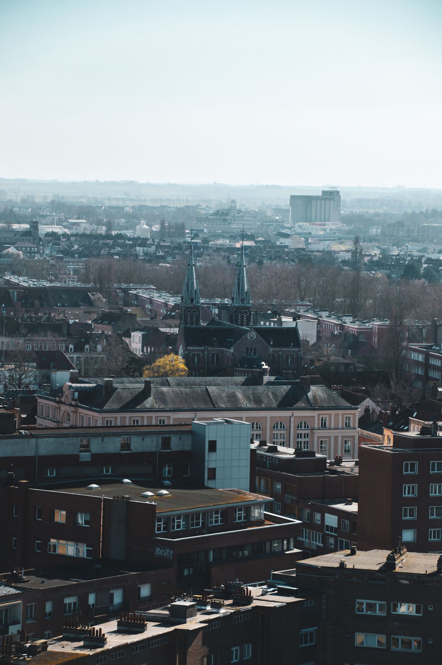 Urban cityscape showing rows of brick buildings and rooftops stretching into the distance.