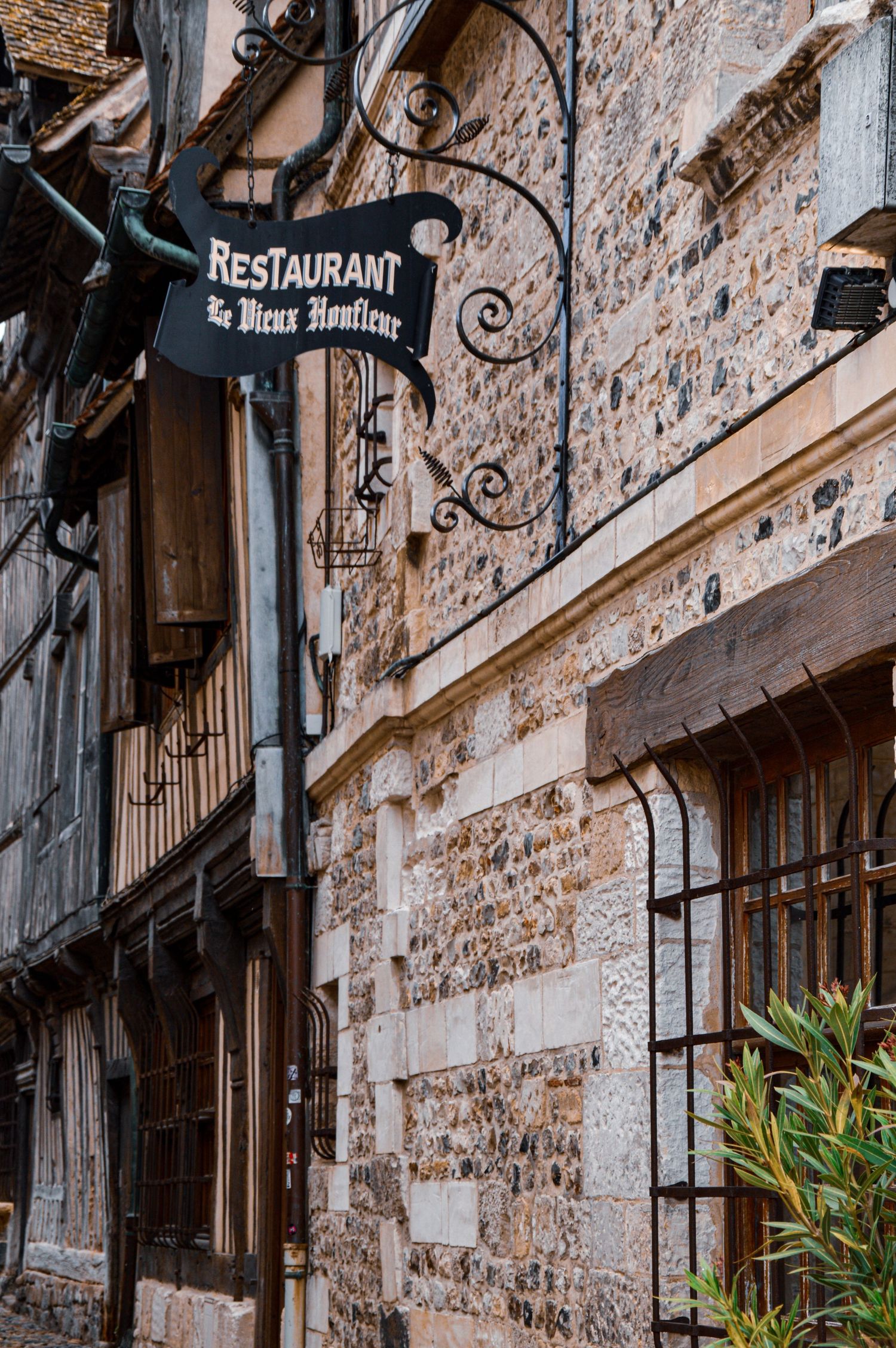 Vintage restaurant sign on weathered stone wall in medieval European town.
