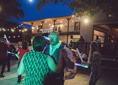 Couple dancing outdoors at night under string lights at Josabi's Acres event venue in Helotes, Texas with glowing decorations.