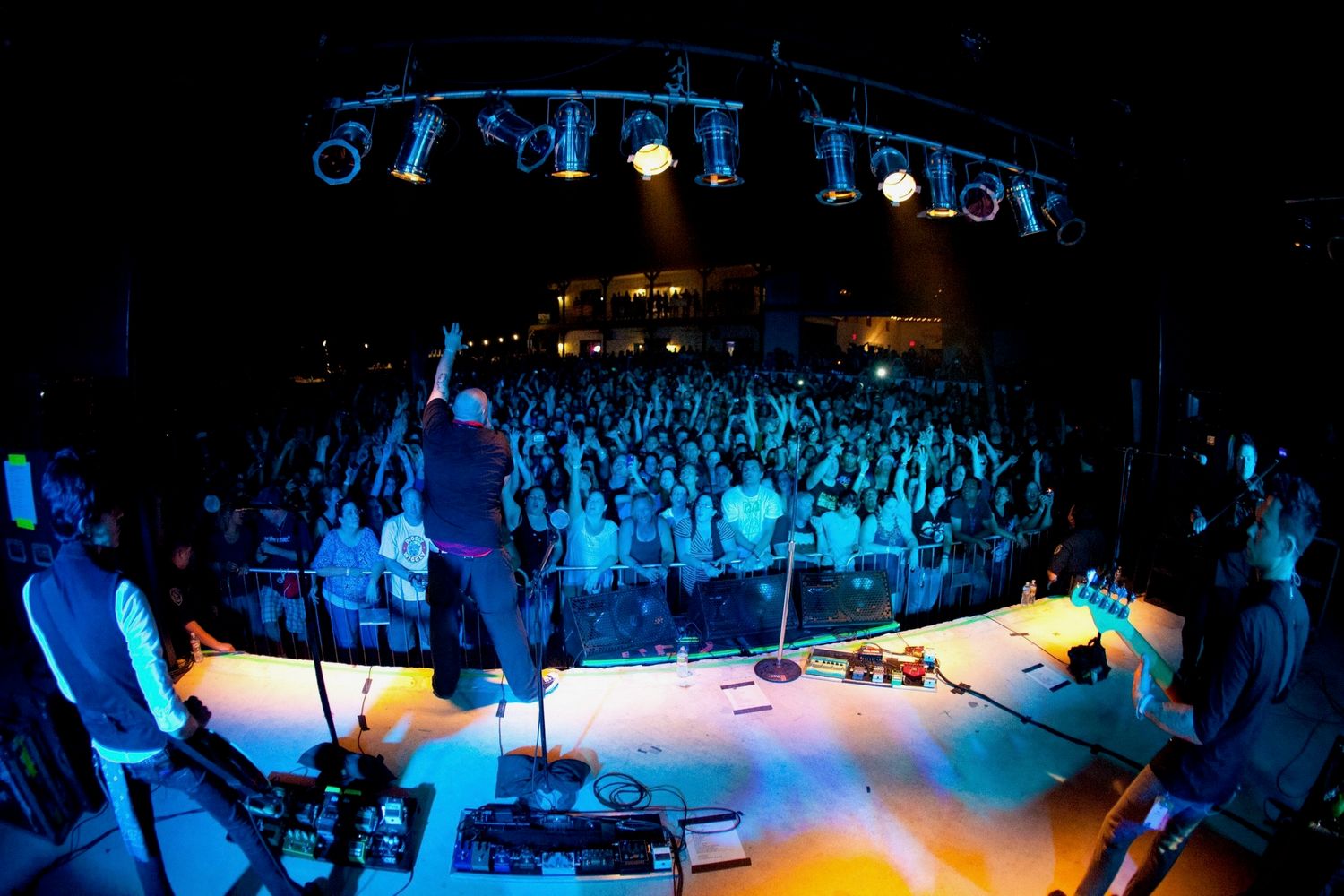 Band performs on stage with dramatic lighting to a large crowd at Josabi's Live in Helotes, TX - an outdoor concert venue.