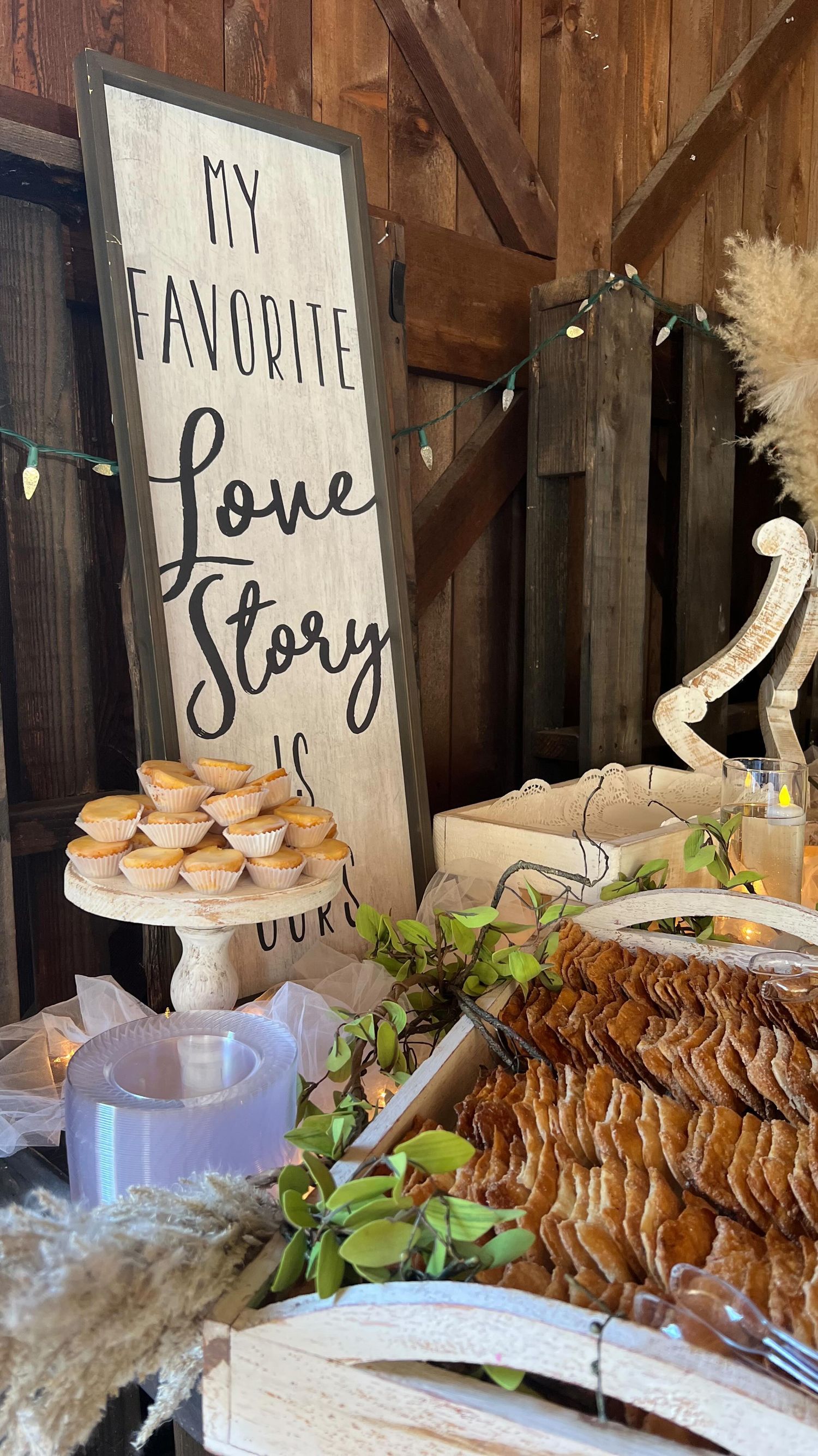 Rustic barn dessert table with Love Story sign, mini pies, and decorative dried floral arrangements at Josabi's Acres in Helotes, Texas.