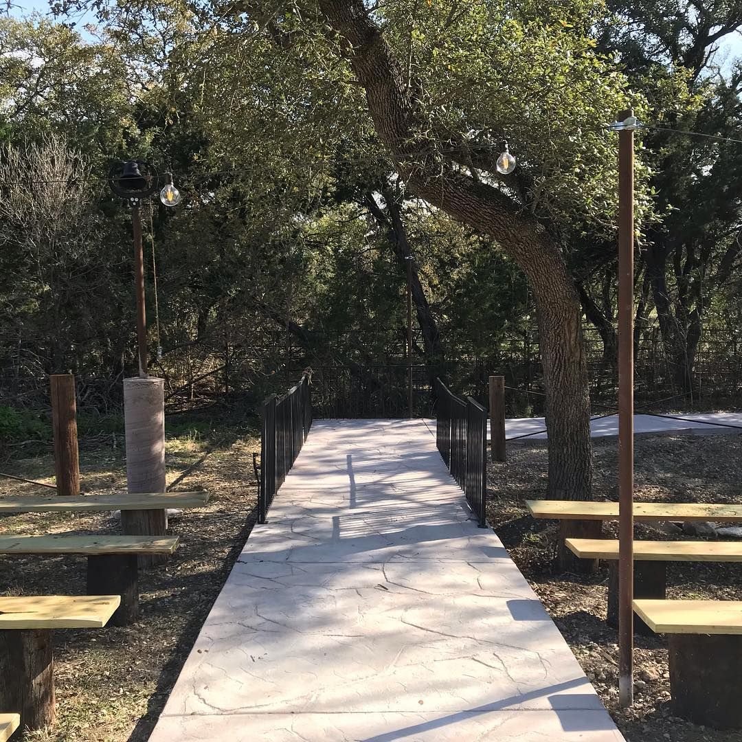A peaceful bridal walk surrounded by lush green oak trees in a natural outdoor setting at Josabi's Acres in Helotes, Texas