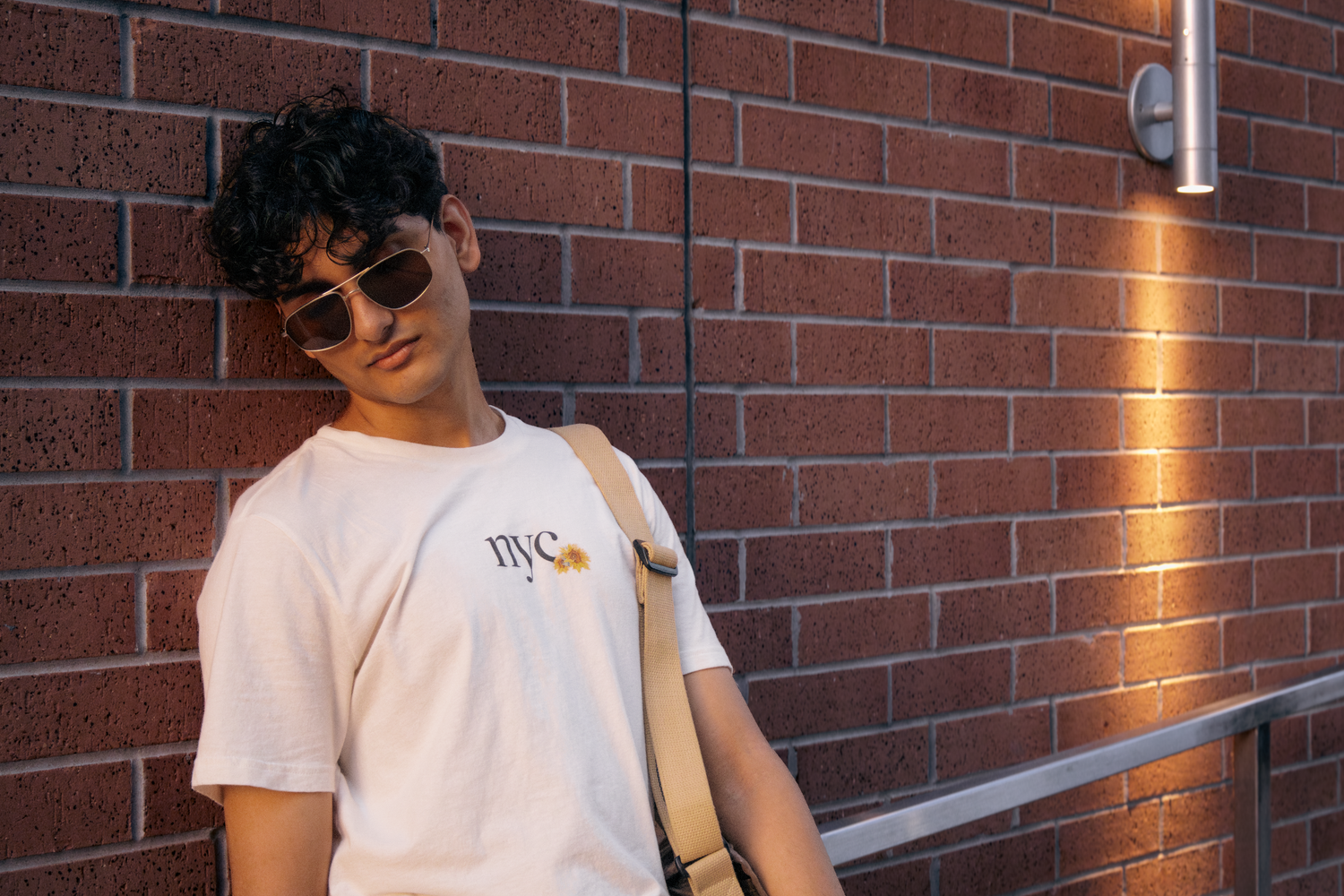 Guy standing against a brick wall