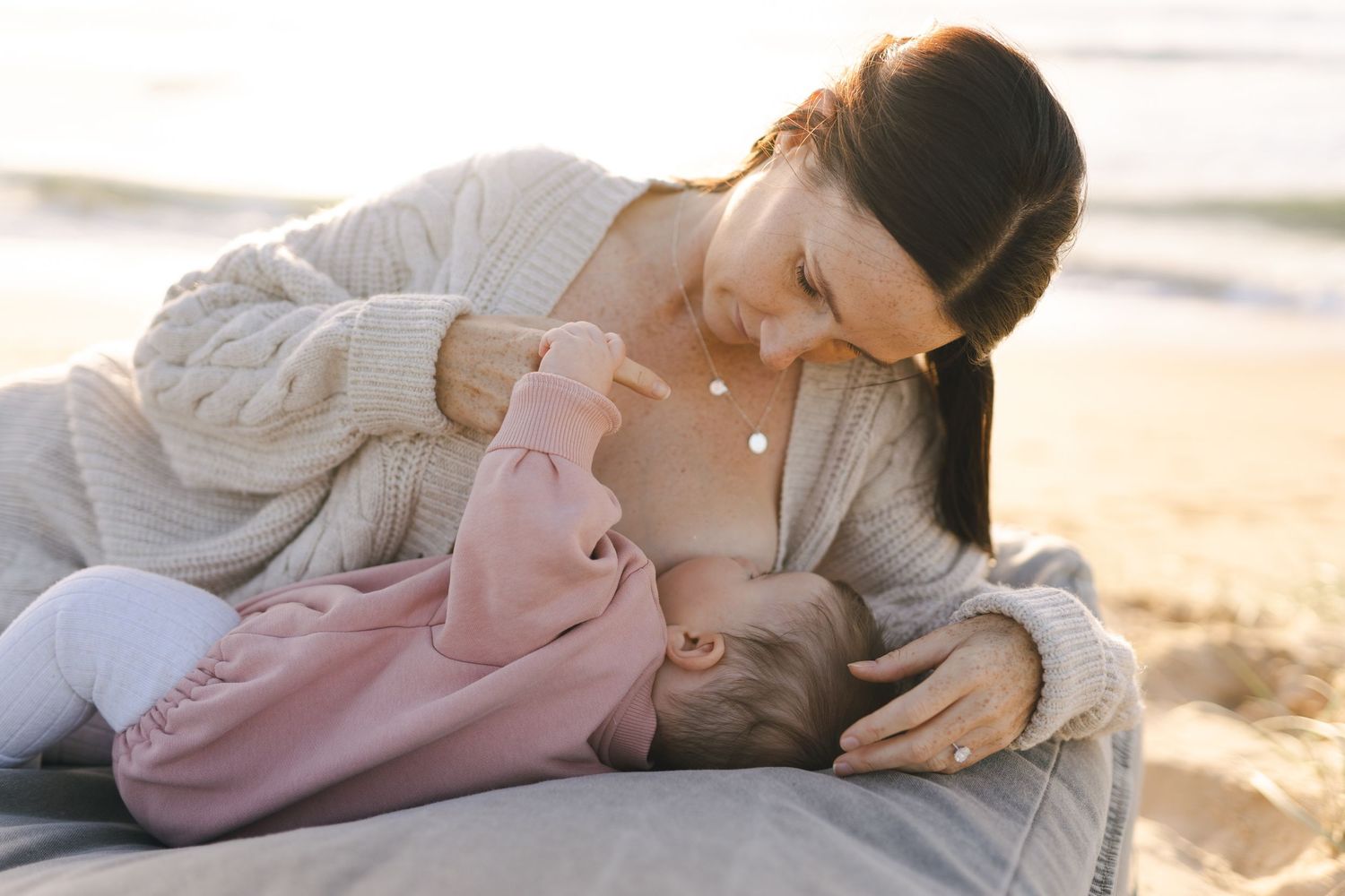 Mother embracing her baby at the beach during a Sunshine Coast breastfeeding photography session