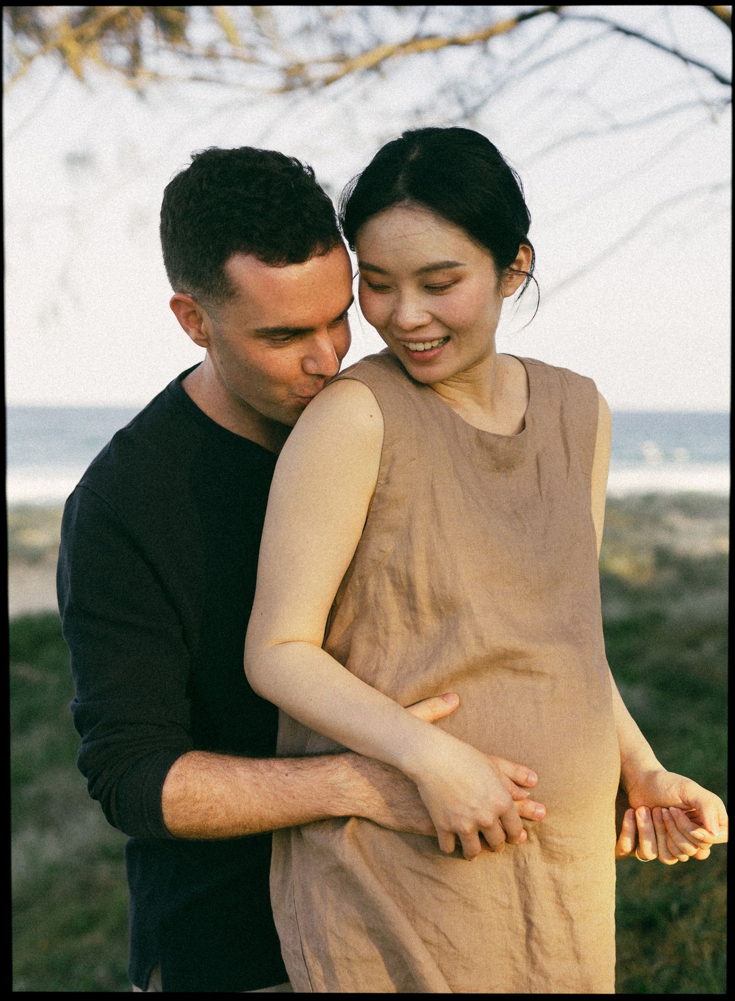 Pregnant mother being embraced her partner during a Sunshine Coast maternity photography session