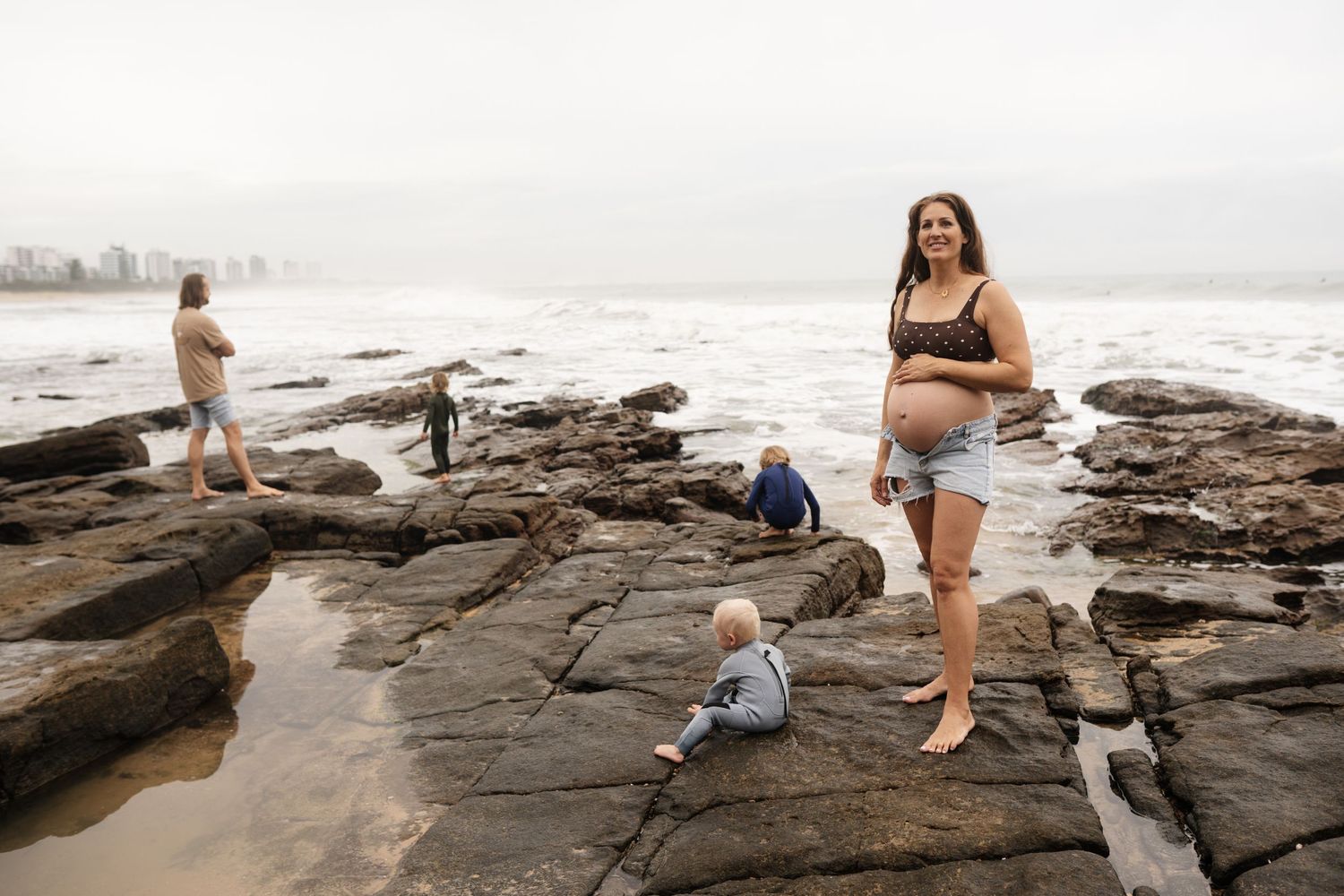 Family of five playing together on the beach during a Sunshine Coast family photography session
