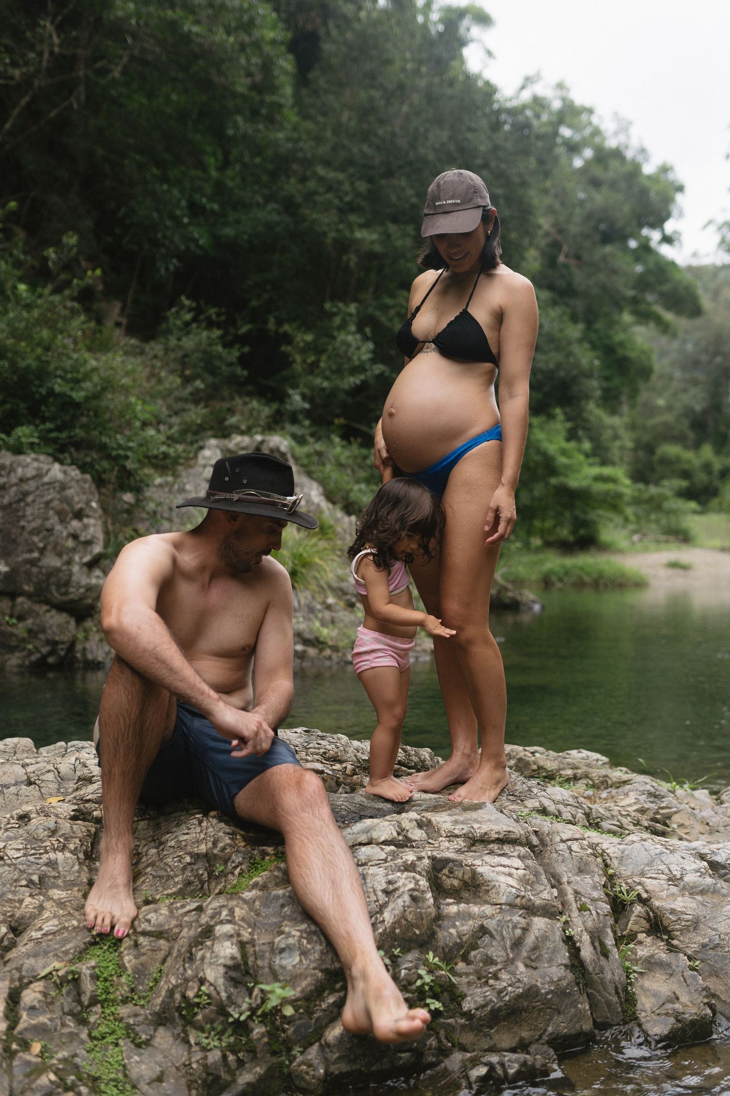 Expecting mother and family exploring the creek together during a documentary family session