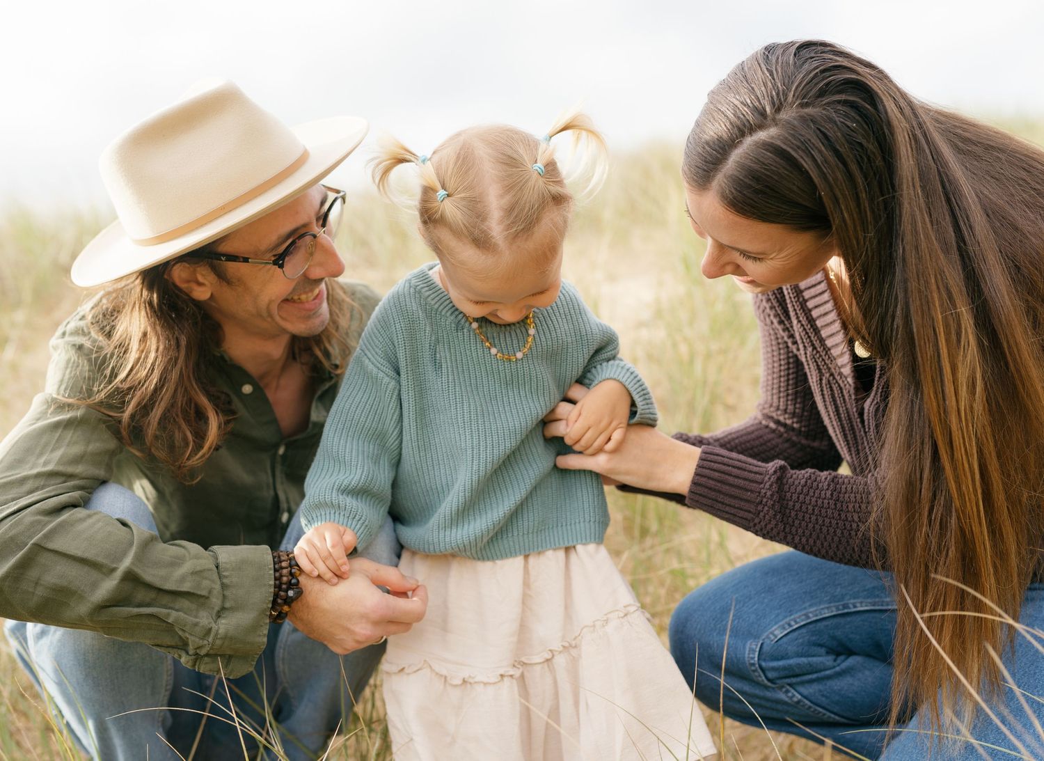 Family of three playing together on the beach during a Sunshine Coast family photography session