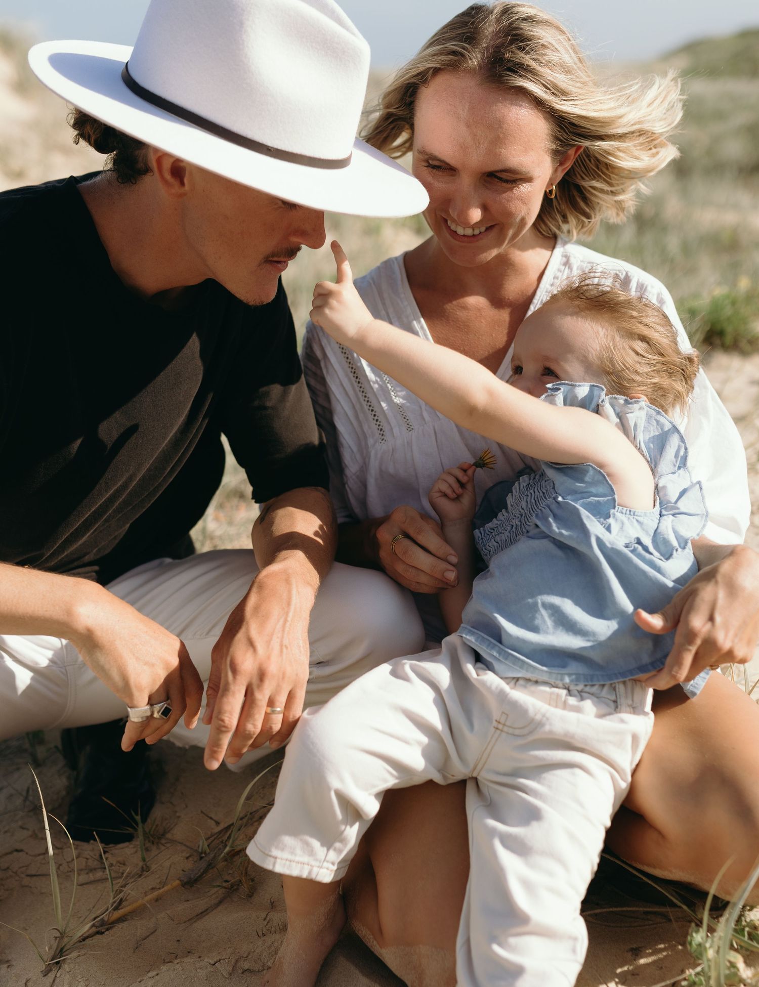 Family of three playing together on the beach during a Sunshine Coast family photography session