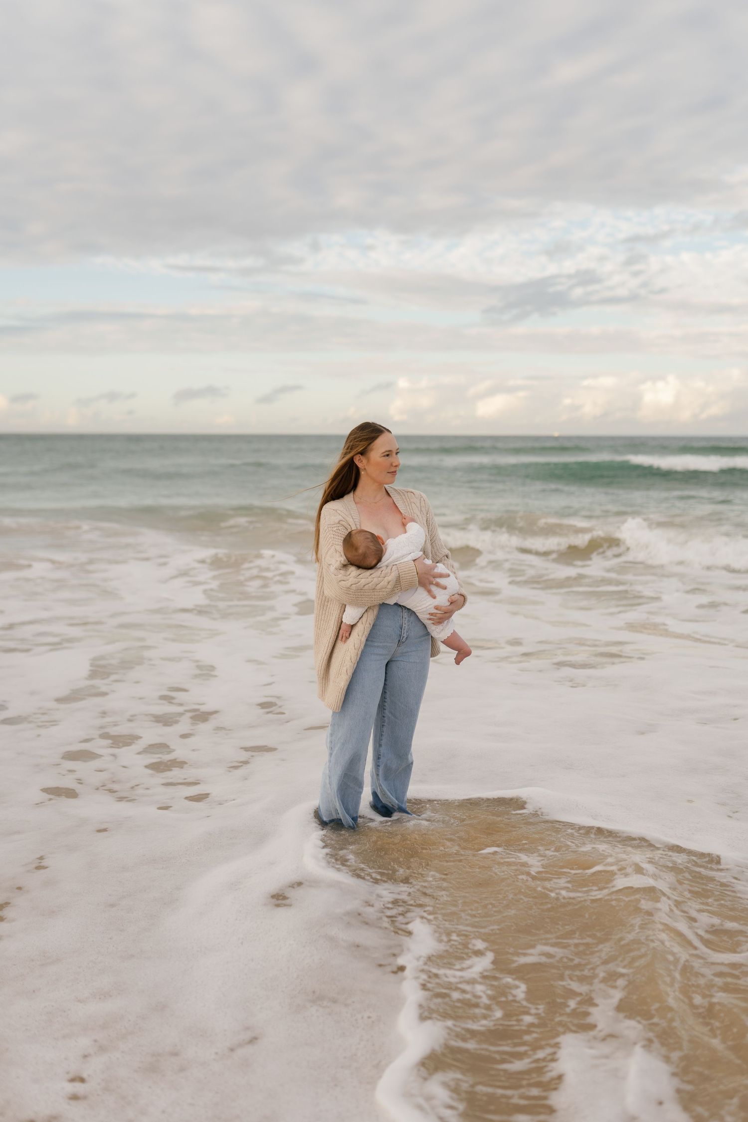 Tender mother and baby connection captured at the beach through authentic motherhood photography