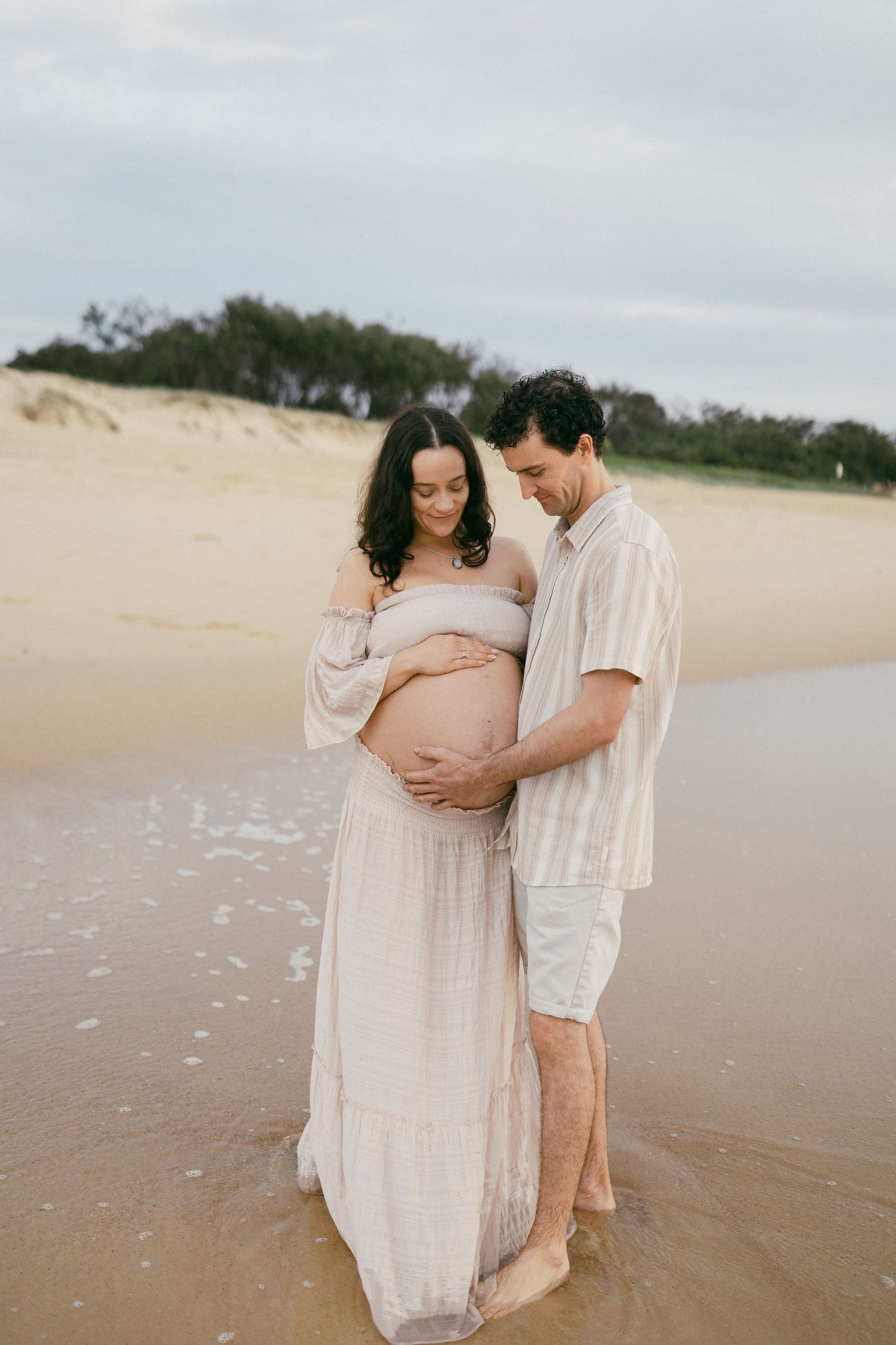 Couple sharing a quiet moment during an outdoor pregnancy photo session