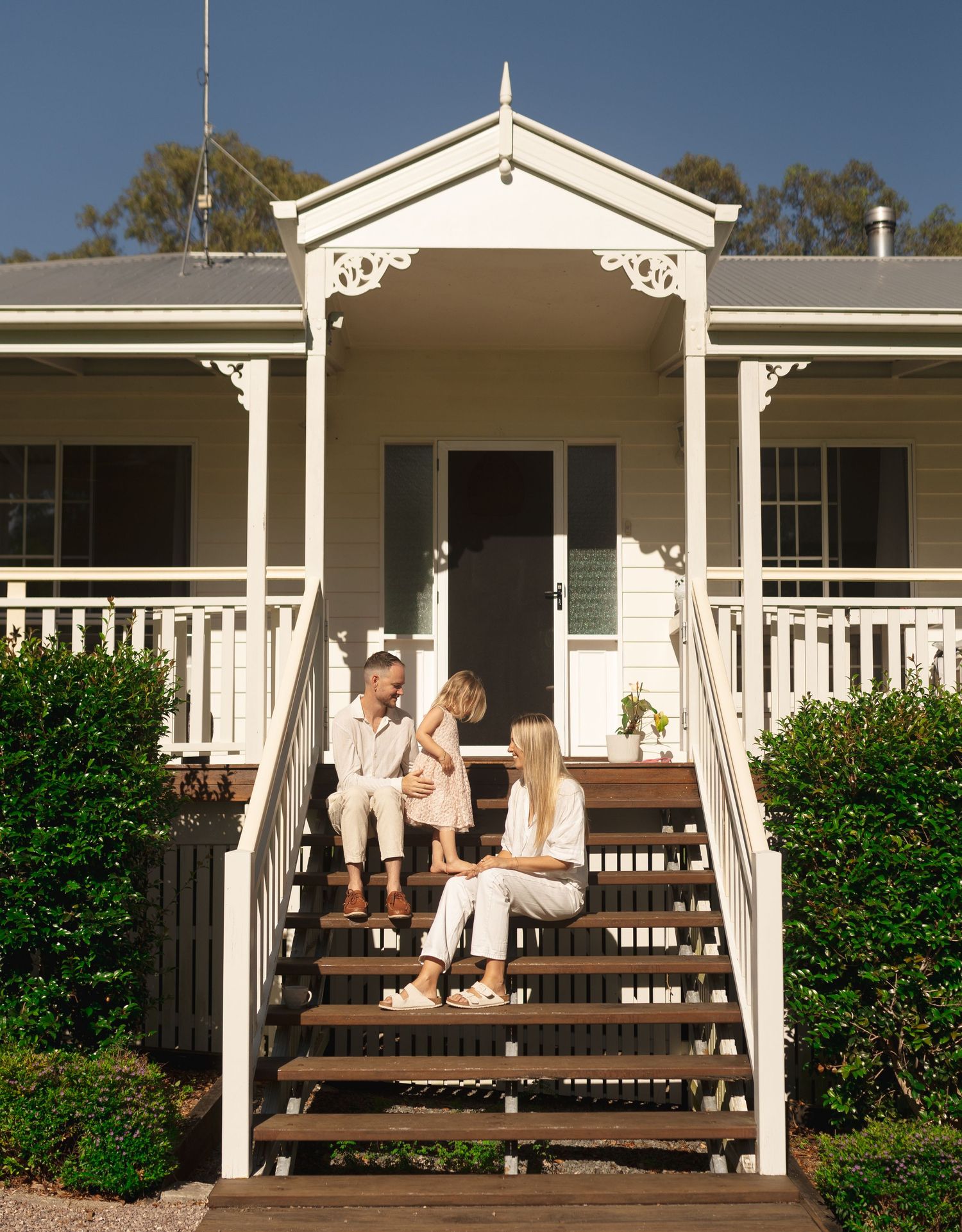 Family of three enjoying the morning sun together at home during Sunshine Coast family photography session