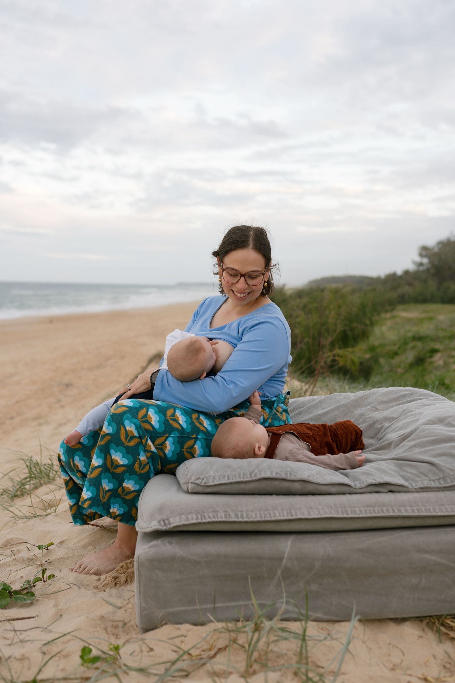 Mother breastfeeding her twins during a relaxed motherhood photography session
