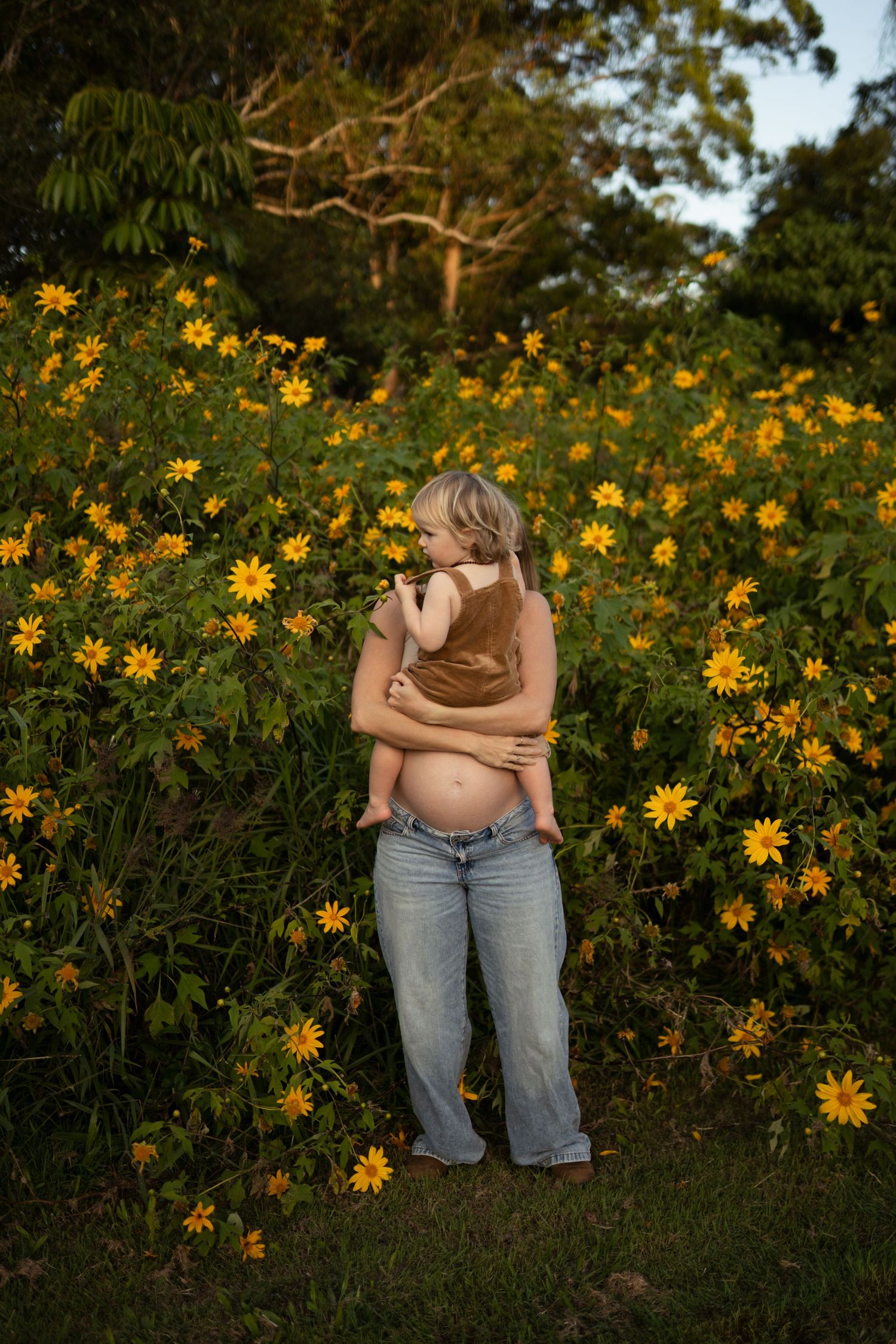 Pregnant mother and toddler sharing a quiet cuddle during a heartfelt maternity session