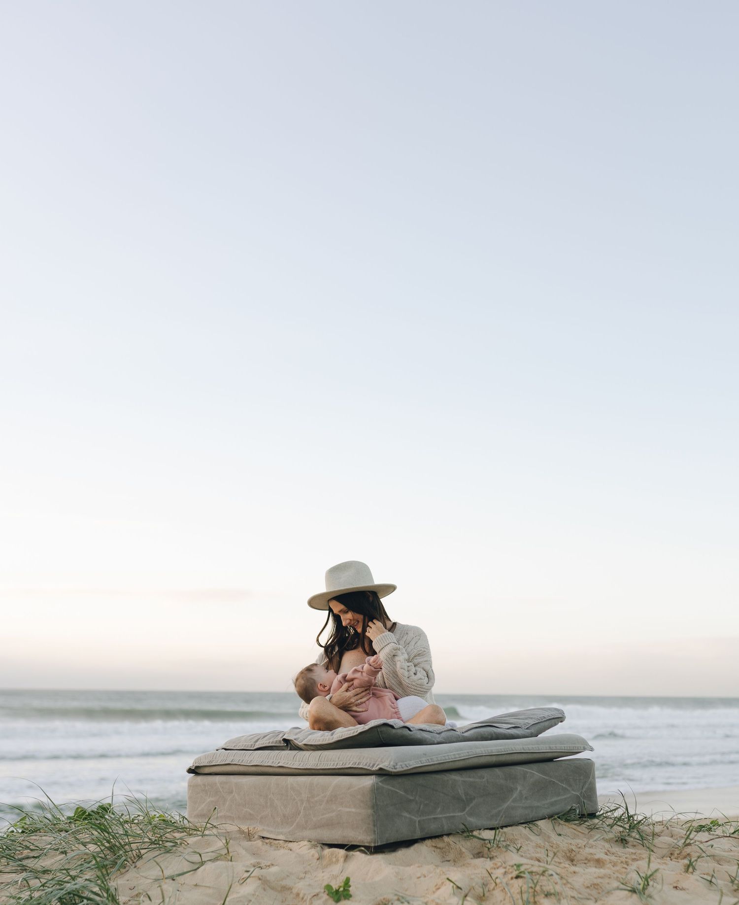 Cosy breastfeeding moment between mother and baby on a winter beach