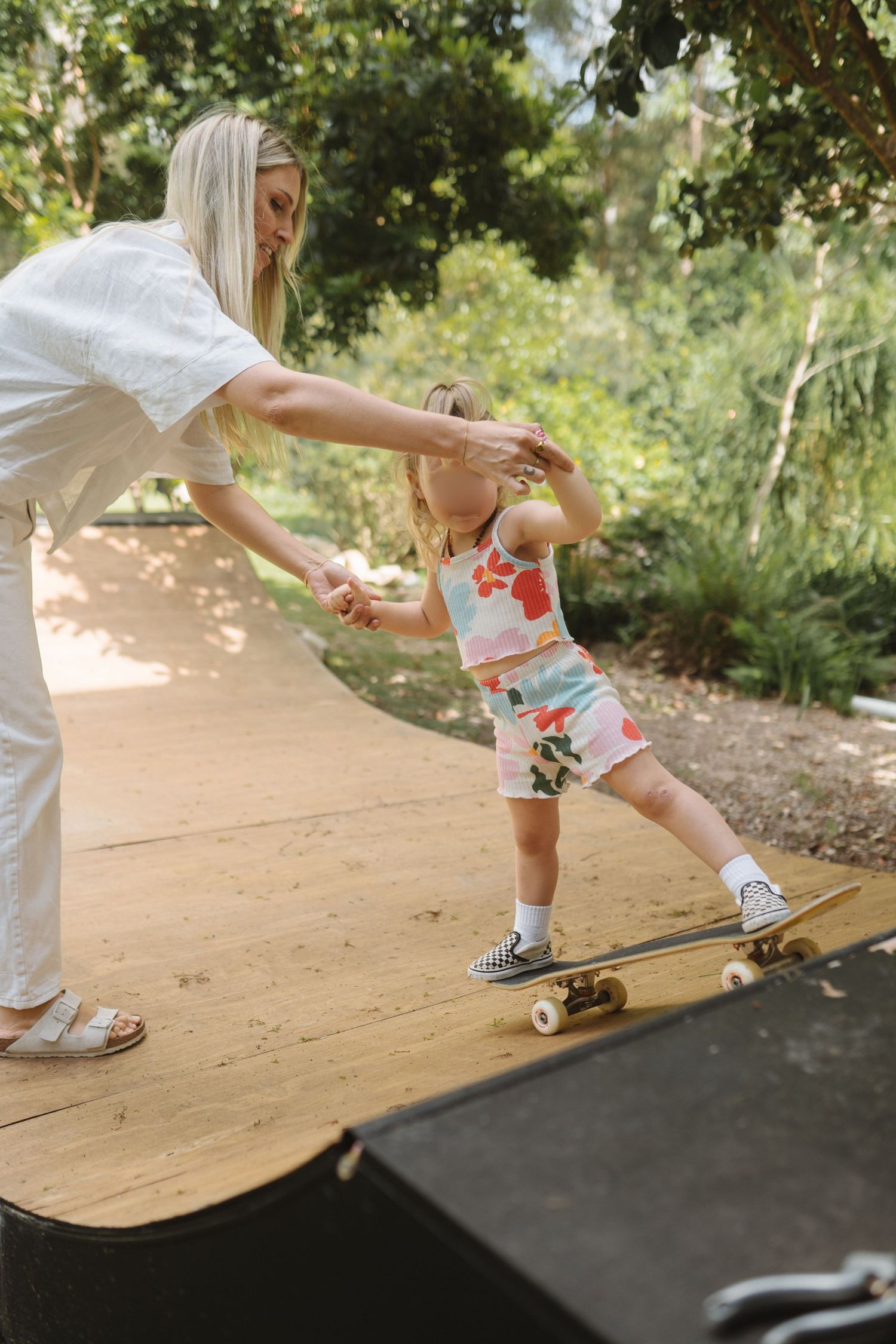 Mother and daughter skateboarding together during a playful family photography session