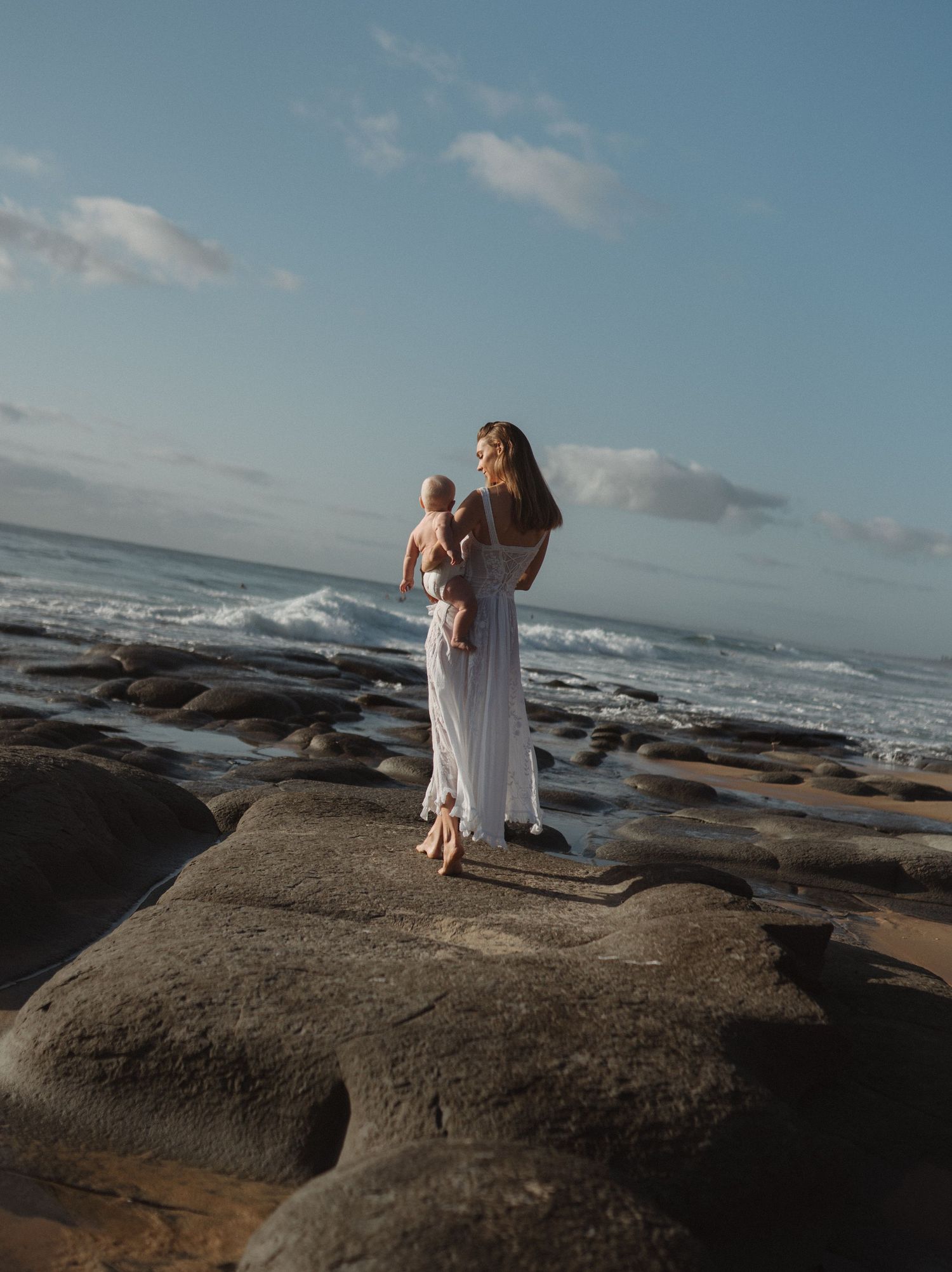 Mother and baby connection at the beach captured through relaxed documentary photography