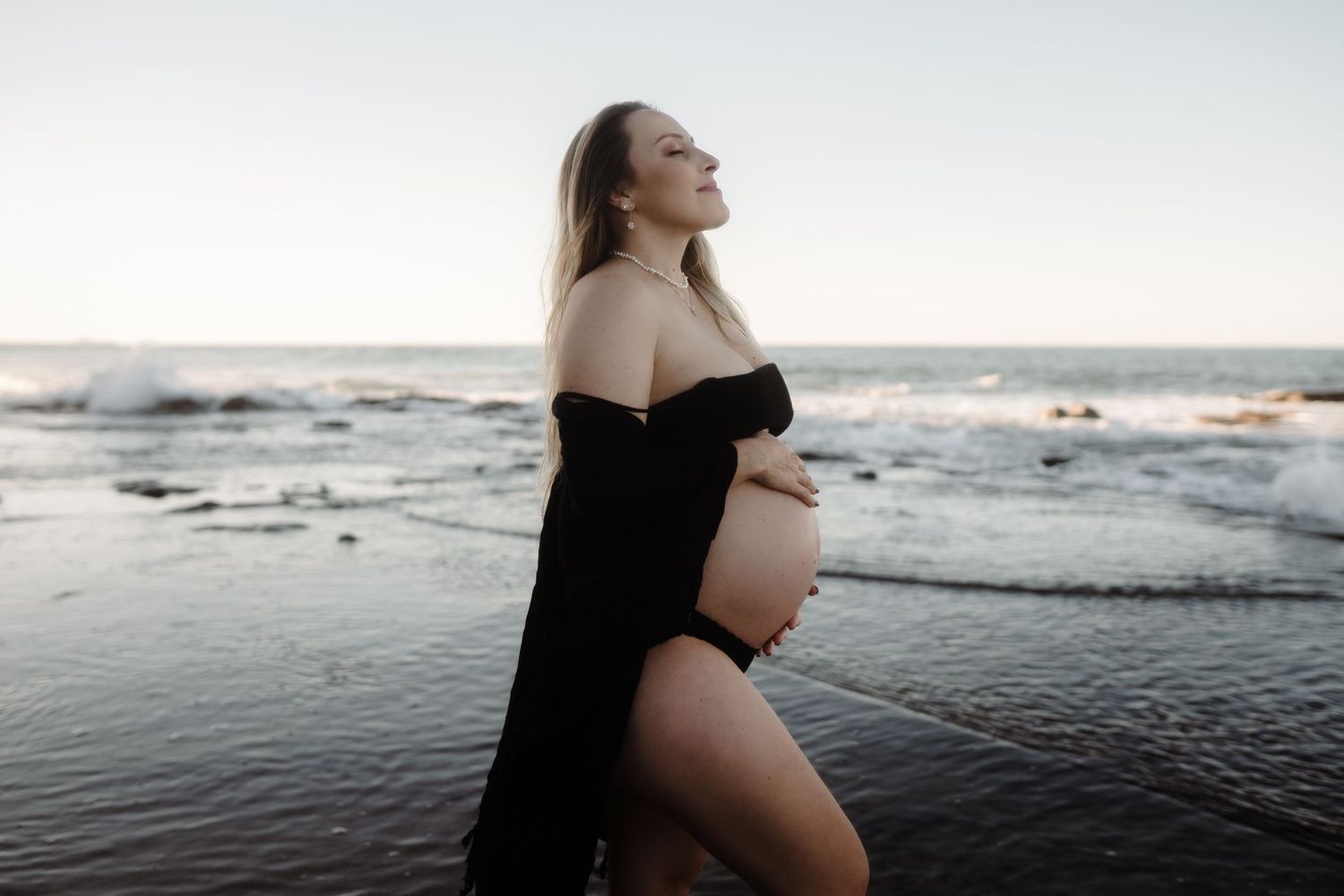 Pregnant mother embracing her changing body during a heartfelt maternity session