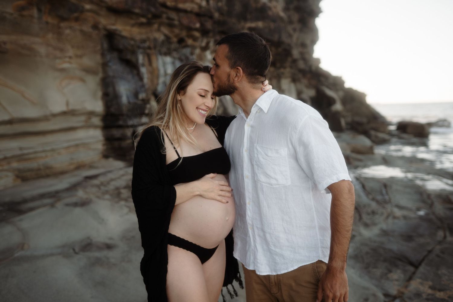 Couple sharing a quiet moment during an outdoor pregnancy photo session
