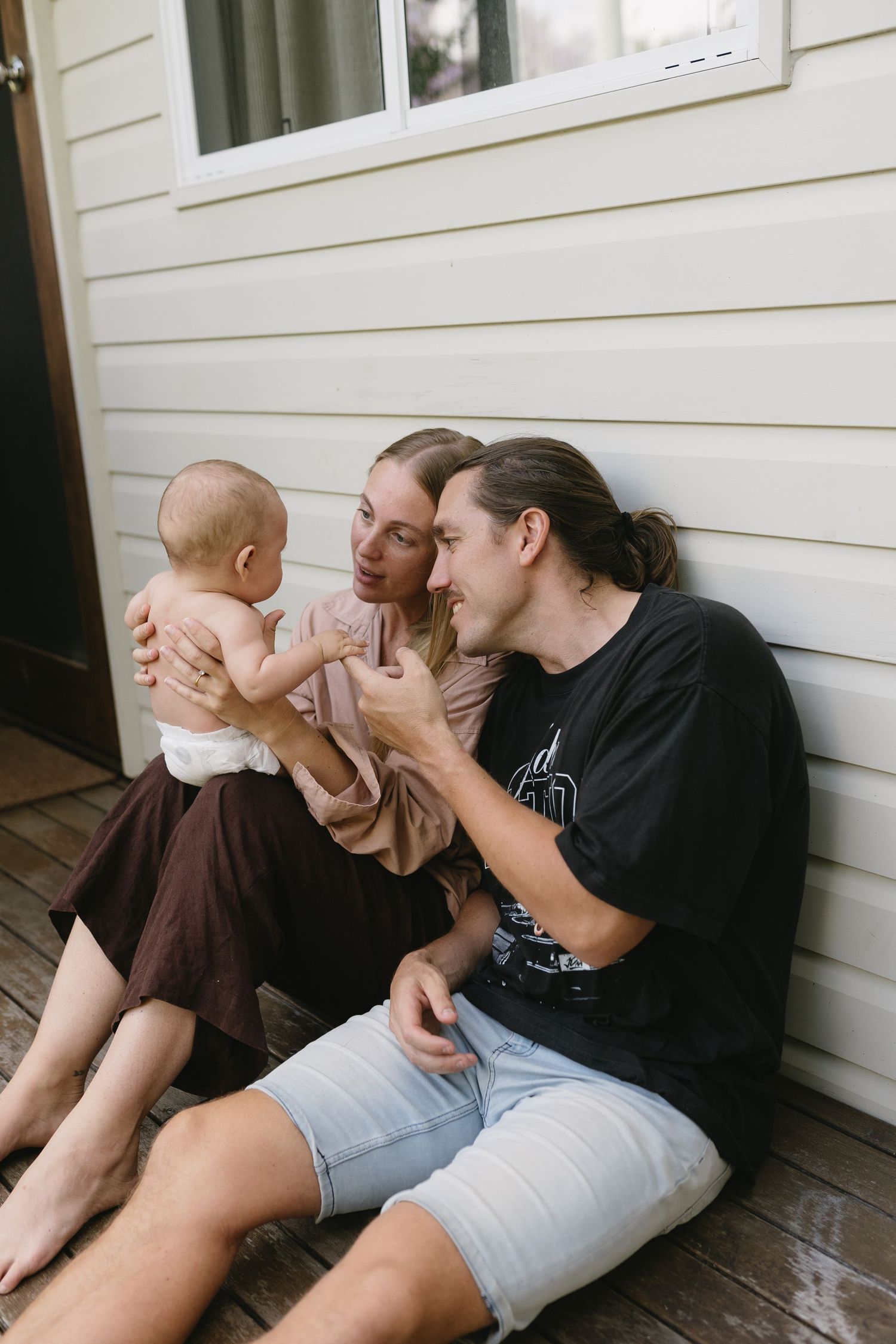 Parents cuddling their baby at home during a newborn photography session