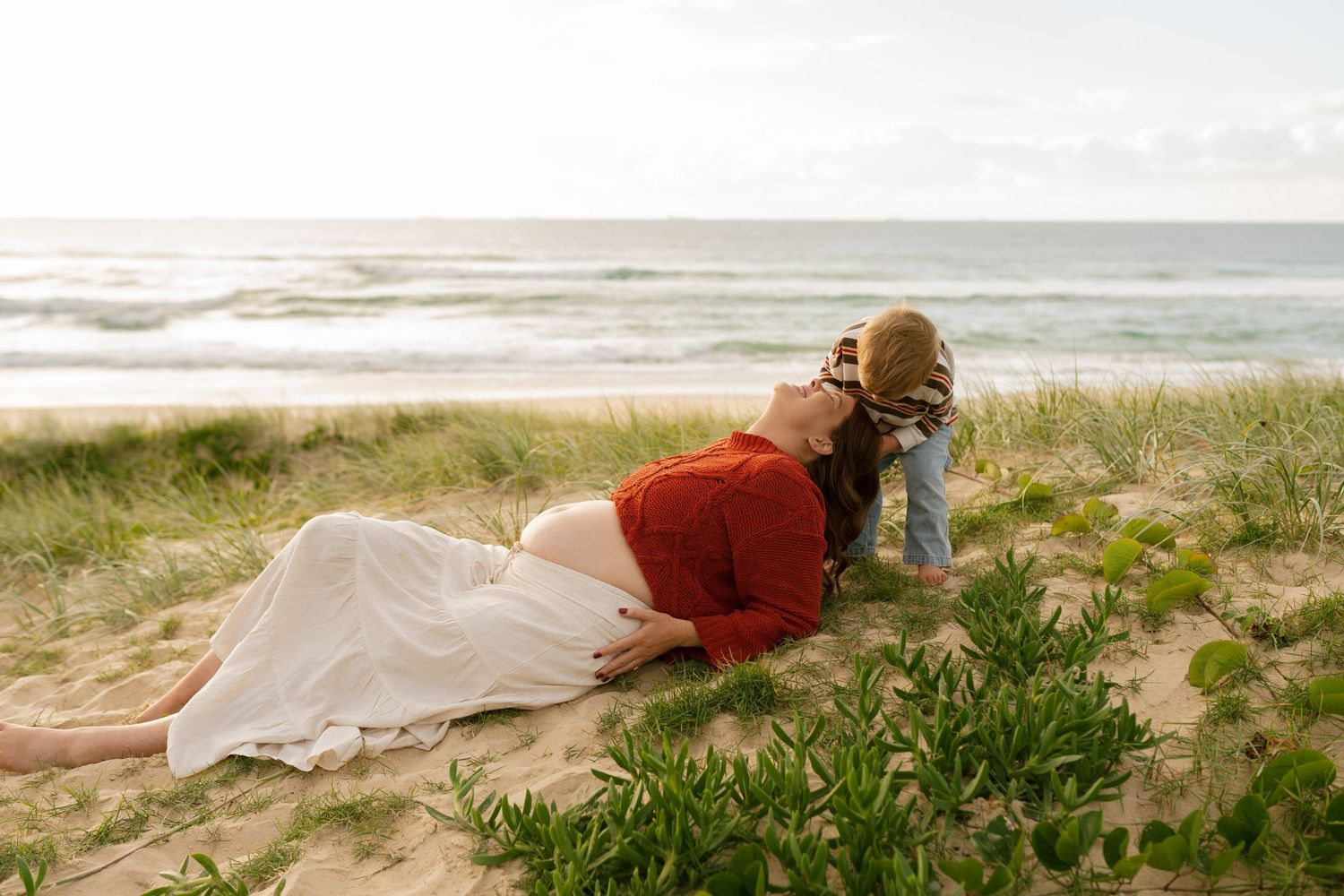 Pregnant mother playing with her toddler during a Sunshine Coast maternity and motherhood photography session