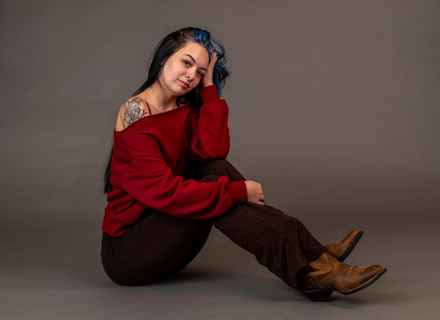 Studio portrait of a woman in a red sweater against a neutral background